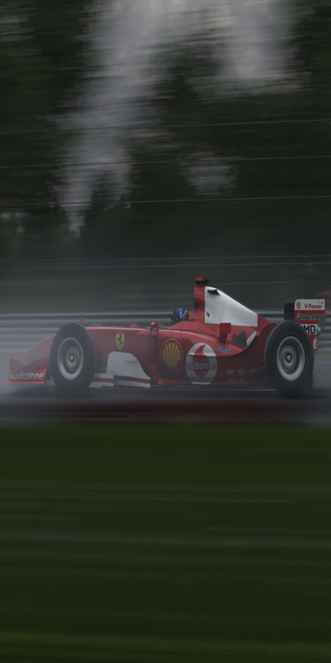 F1 桌布 壁紙 — 一輛紅色法拉利一級方程式賽車在濕滑的彎道上疾馳，動態模糊效果掠過綠色的賽道旁風景。