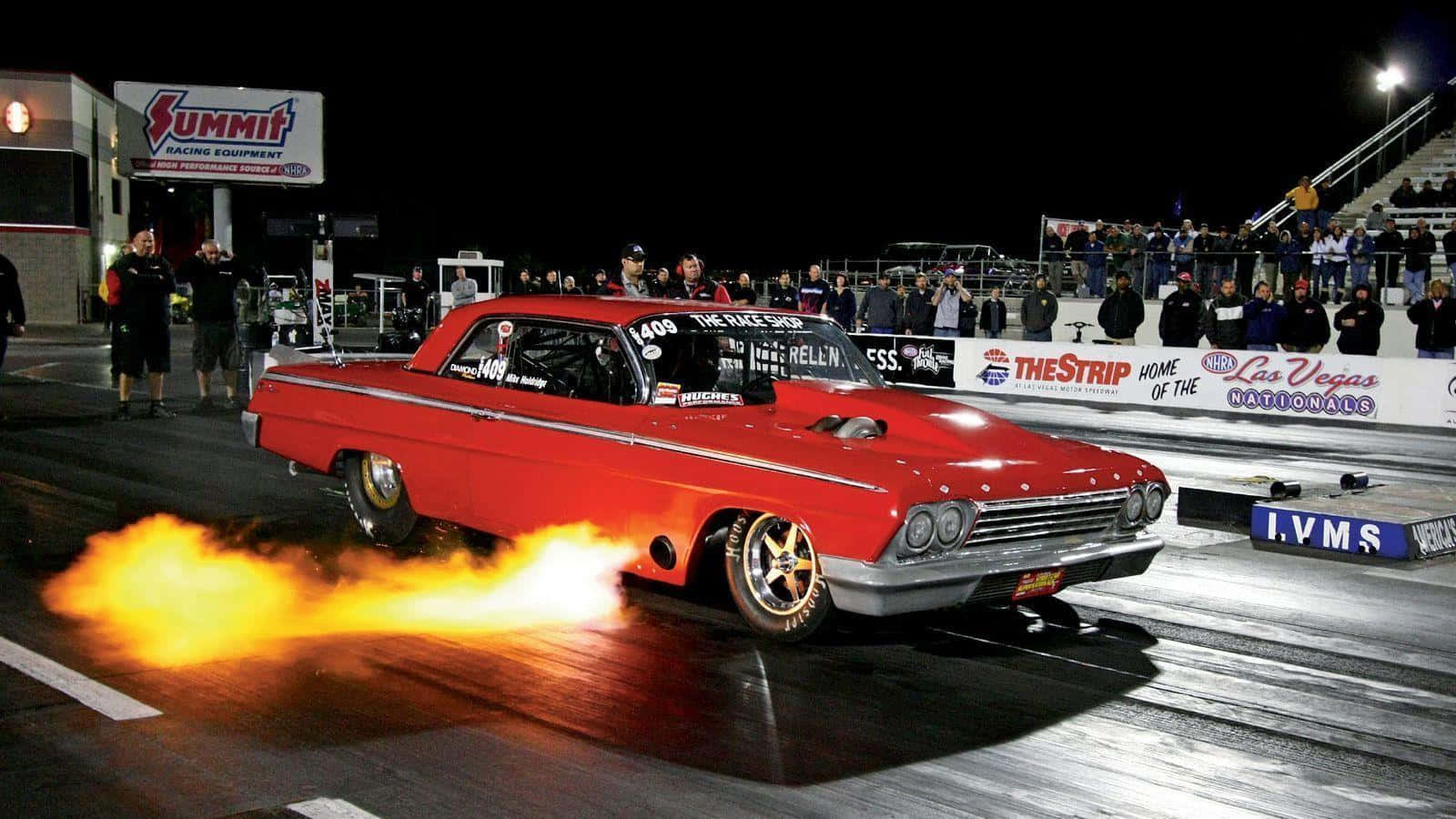 chevy 桌布 壁紙 — 一輛紅色經典直線加速賽車在夜間拉斯維加斯全國賽中從後輪噴出火焰。