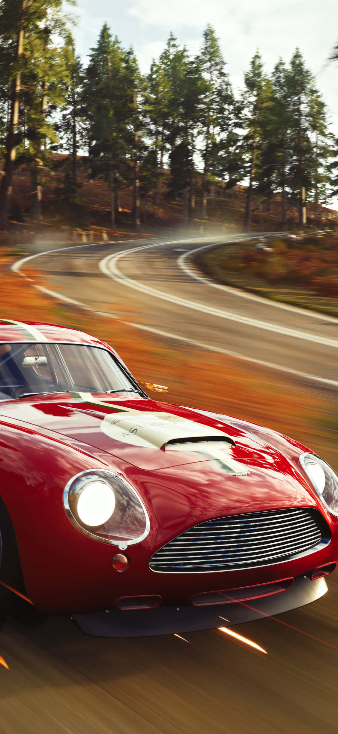 iPhone X Forza Horizon 4 桌布 壁紙 — 一輛紅色經典跑車在蜿蜒的森林道路上疾馳，帶有動態模糊和發光的車頭燈。