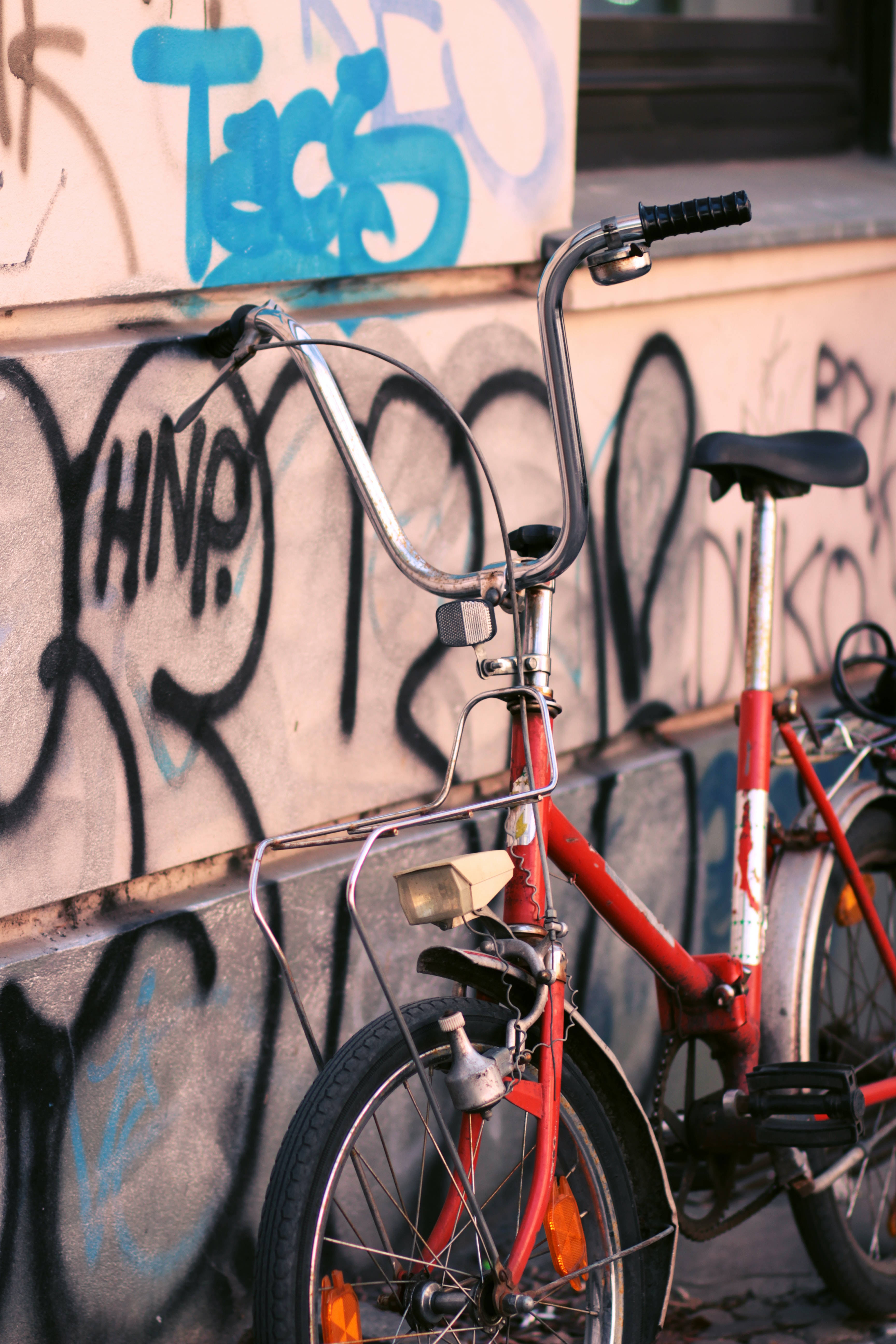 Bicycle 桌布 壁紙 — 一輛紅色腳踏車靠在一幅被塗鴉覆蓋的牆上，沐浴在溫暖的黃金時刻光線中。