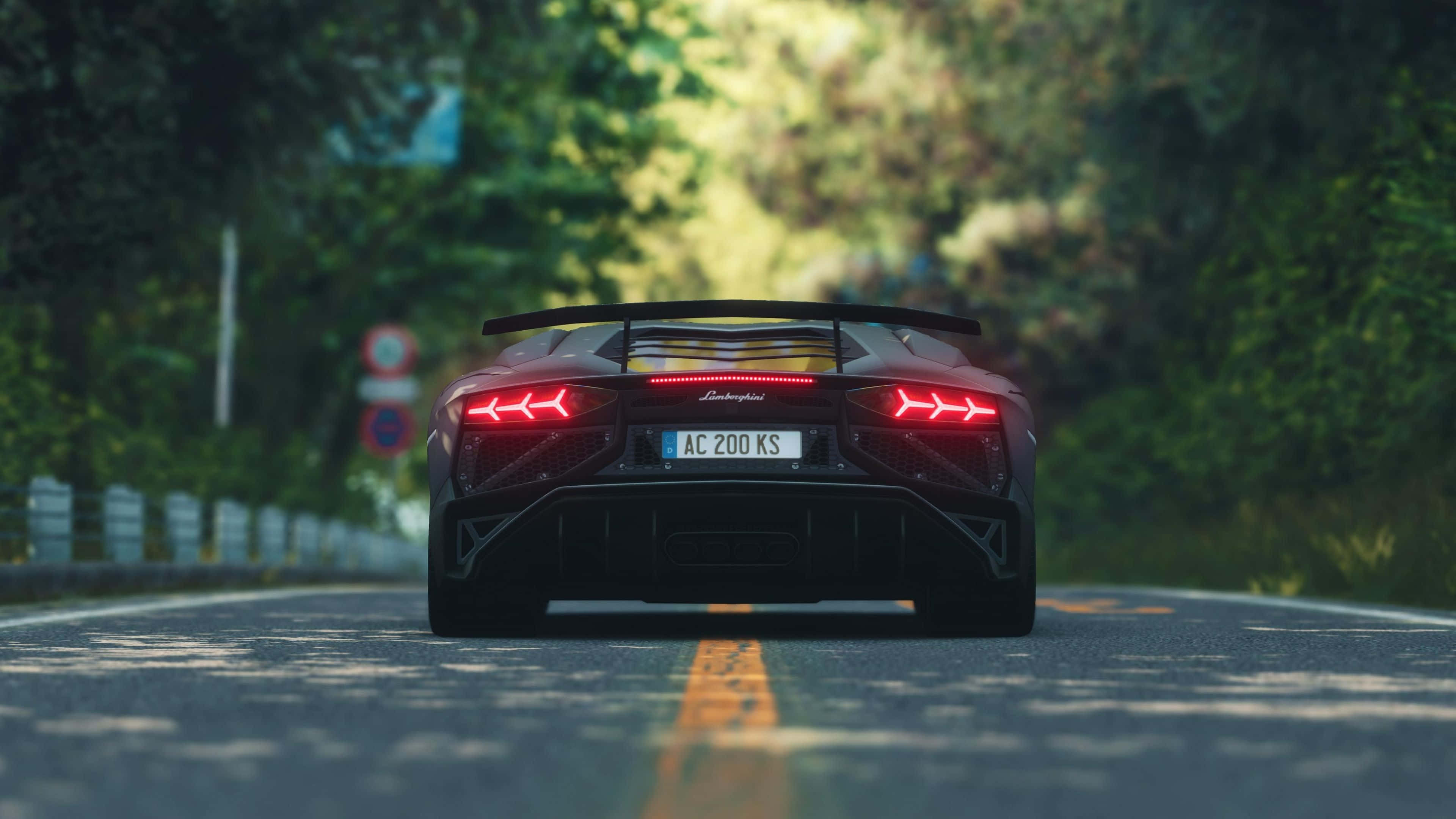 4K 藍寶堅尼 桌布 壁紙 — 一輛紅色藍寶堅尼 Aventador SVJ 在陽光明媚的森林道路上駛離，尾燈閃爍發光。