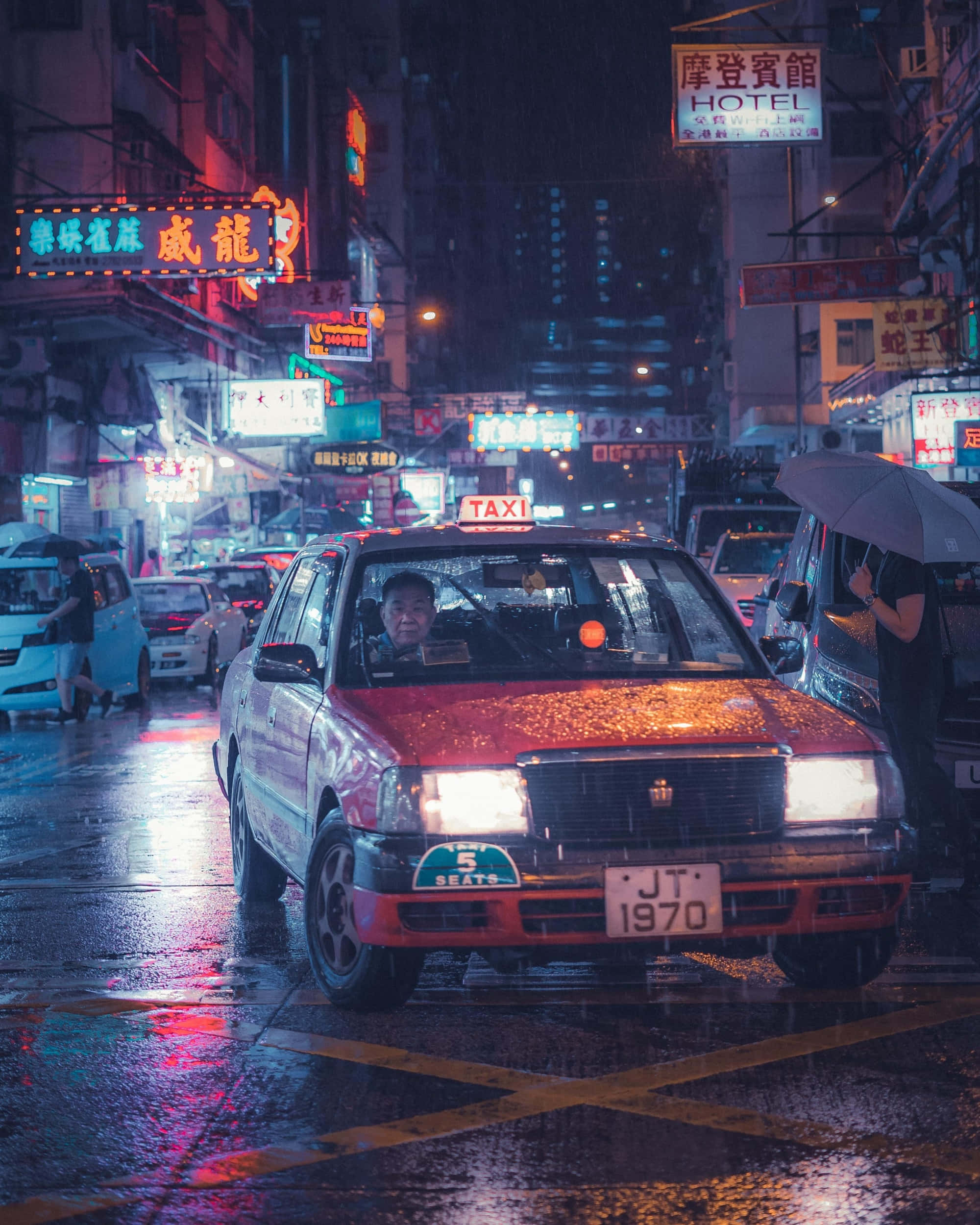 taxi 桌布 壁紙 — 一輛紅色計程車在夜晚行駛於被雨水浸濕、霓虹燈閃爍的城市街道上，發光的招牌映照在濕漉漉的路面上。