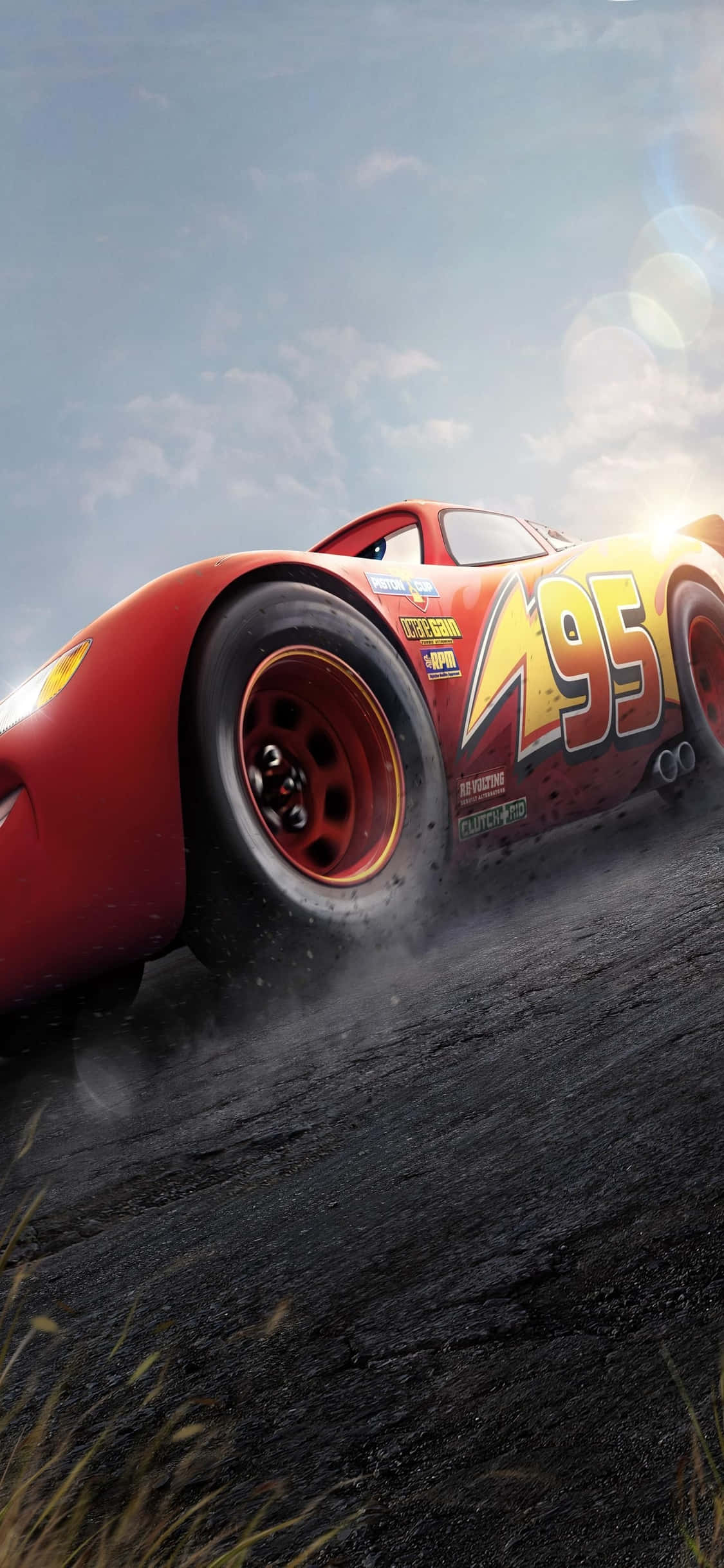 Lightning Mcqueen 桌布 壁紙 — 一輛紅色賽車，編號95，在塵土飛揚的賽道上疾馳，天空明亮，帶有鏡頭光暈。