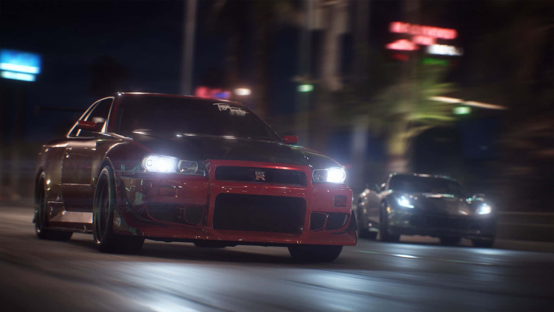 R34 桌布 壁紙 — 一輛紅色跑車在夜晚霓虹燈閃爍的城市街道上疾馳，車頭燈明亮，留下動態模糊的軌跡。