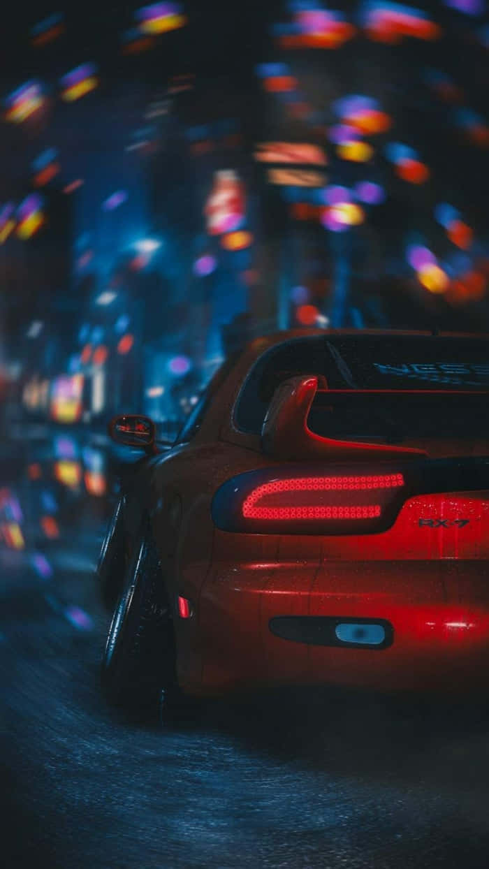 JDM 桌布 壁紙 — 一輛紅色跑車在夜間滑過濕滑的市區街道，鮮豔的散景燈光掠過。