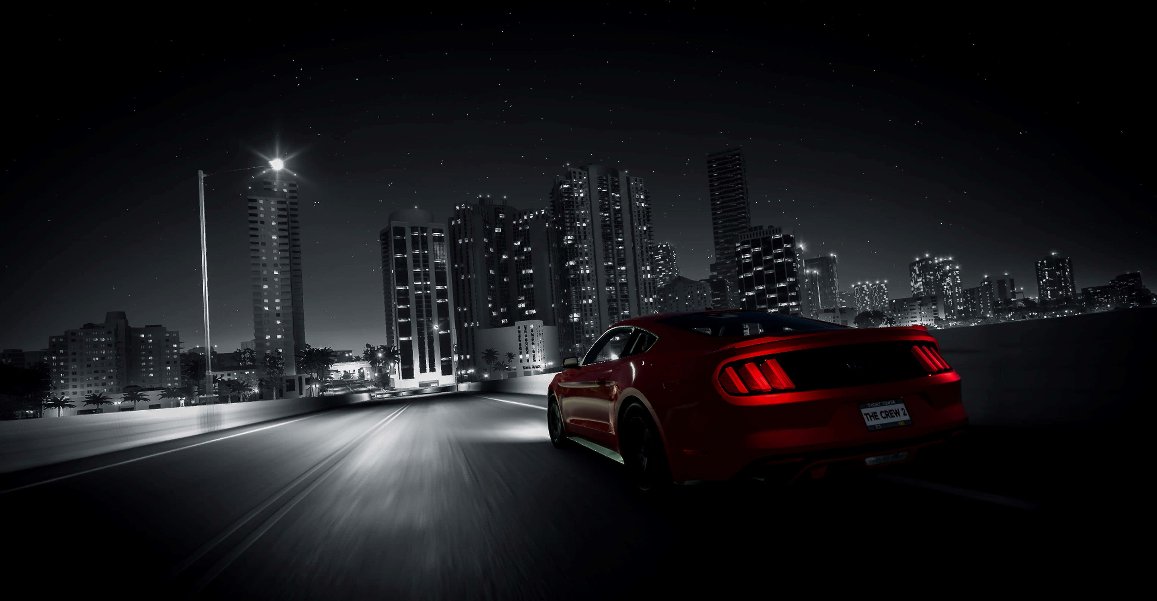 Xbox Games 桌布 壁紙 — 一輛紅色跑車在繁星點點的夜空下，沿著黑暗的高速公路飛馳，背景是單色城市天際線閃爍著光芒。