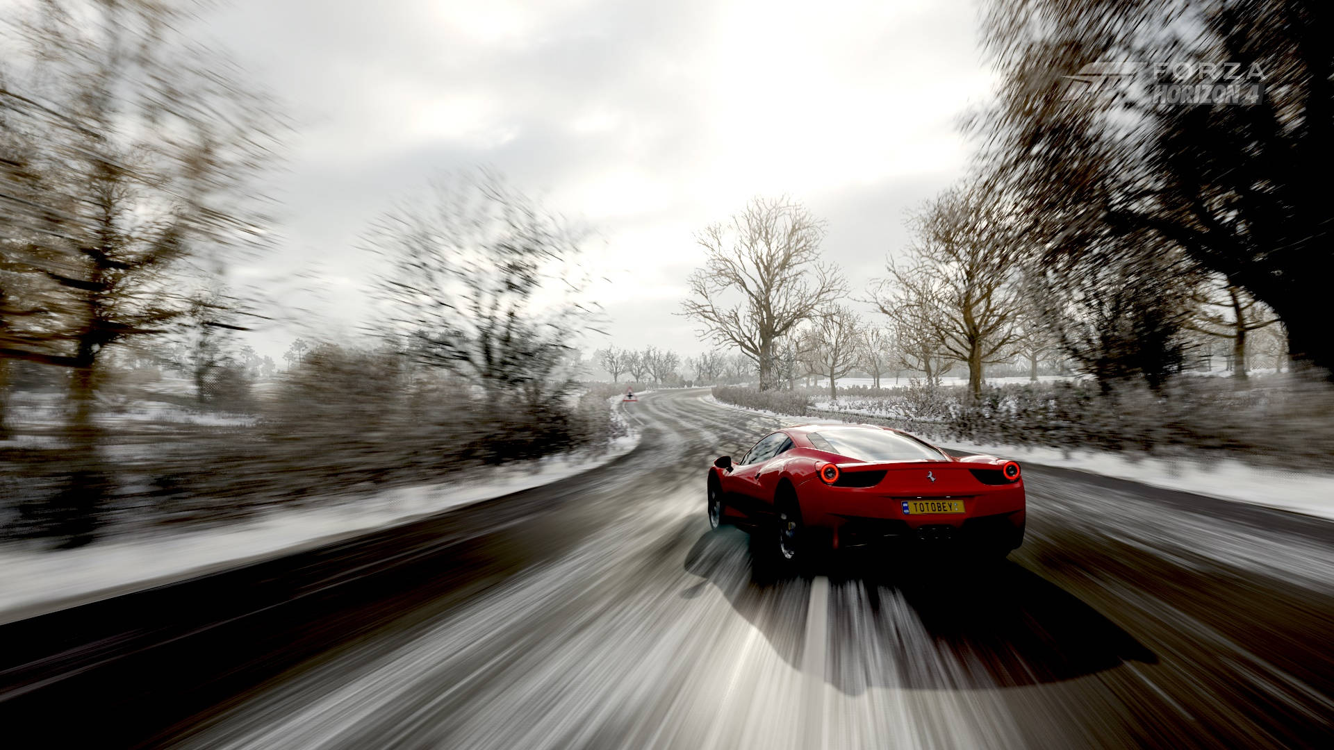Forza Gaming 桌布 壁紙 — 一輛紅色跑車在陰天之下，沿著白雪覆蓋的鄉村道路疾馳，帶有模糊的動感和光禿的樹木。
