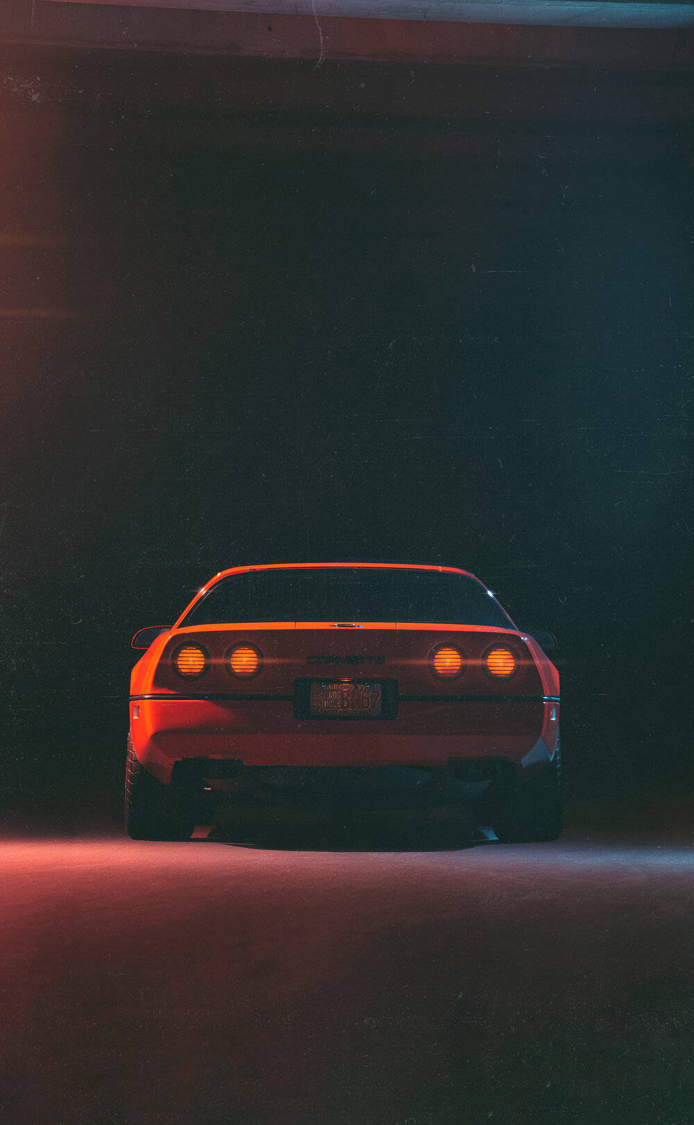 corvette 桌布 壁紙 — 一輛紅色跑車帶有發光的尾燈，停在沐浴在霓虹紅和藍光下的橋樑下方。