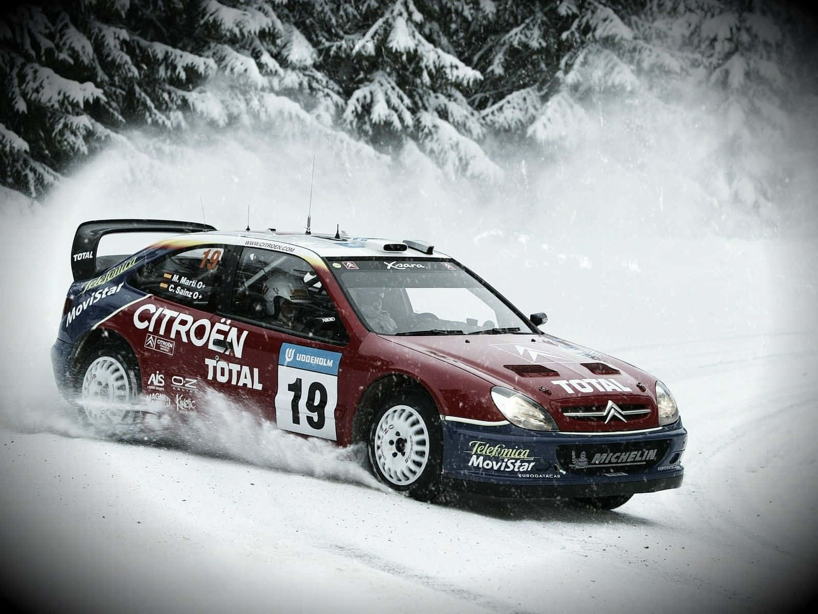 Ice Racing 桌布 壁紙 — 一輛紅色雪鐵龍拉力賽車在冬季比賽中高速穿越雪地森林，揚起雪花。