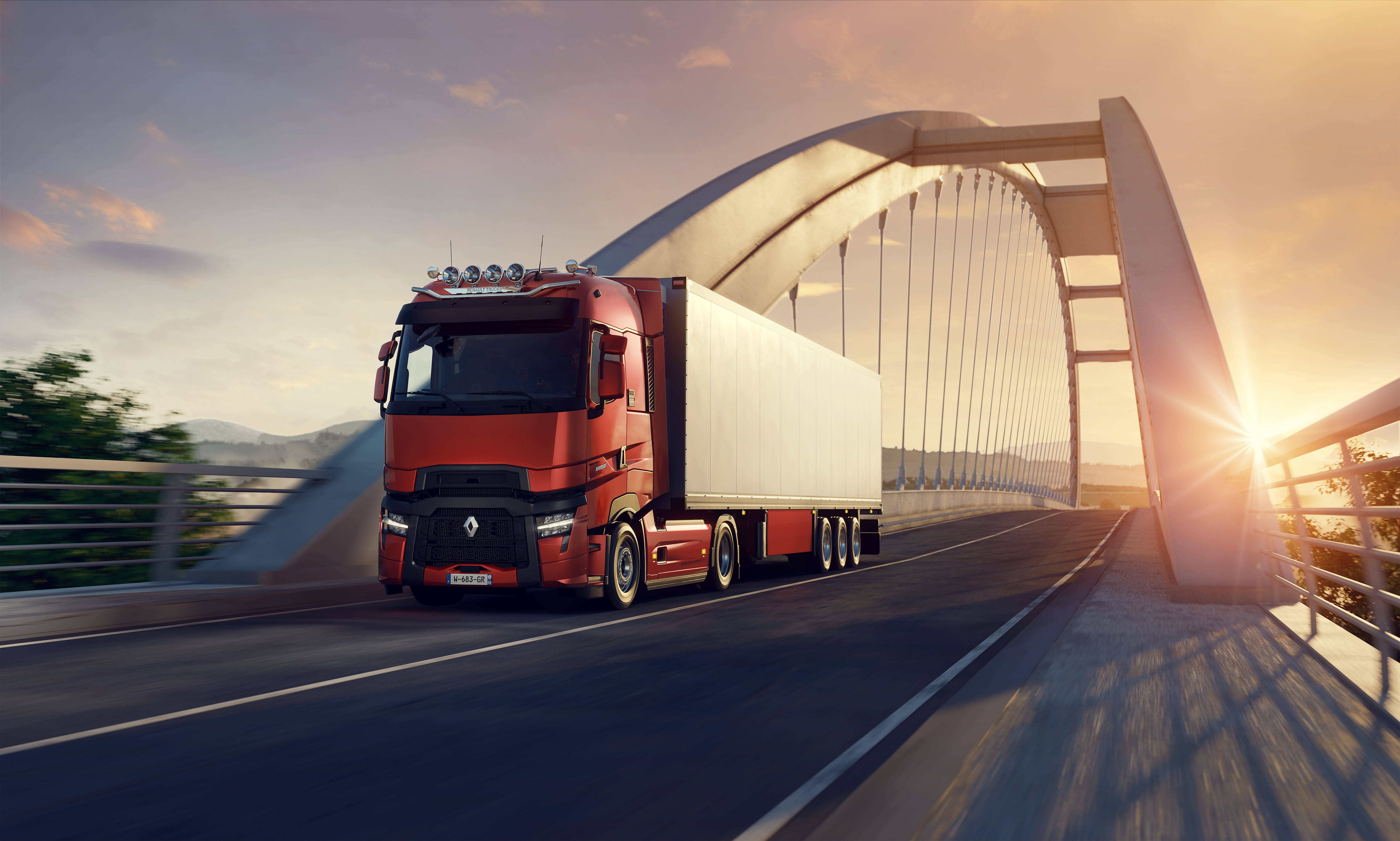 American Truck Simulator 桌布 壁紙 — 一輛紅色雷諾半掛卡車拖著白色拖車，在金色日落時分穿越現代拱橋。