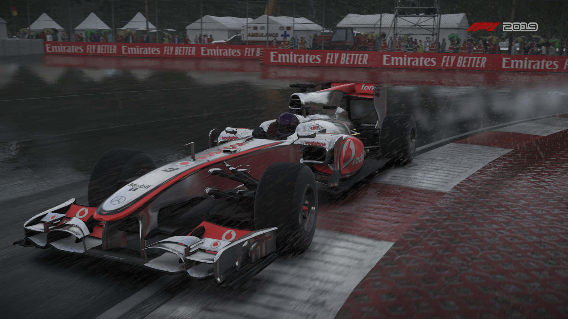 Race Track 桌布 壁紙 — 一輛紅銀色一級方程式賽車在濕滑的賽道上滑過一個濕彎，背景有觀眾。