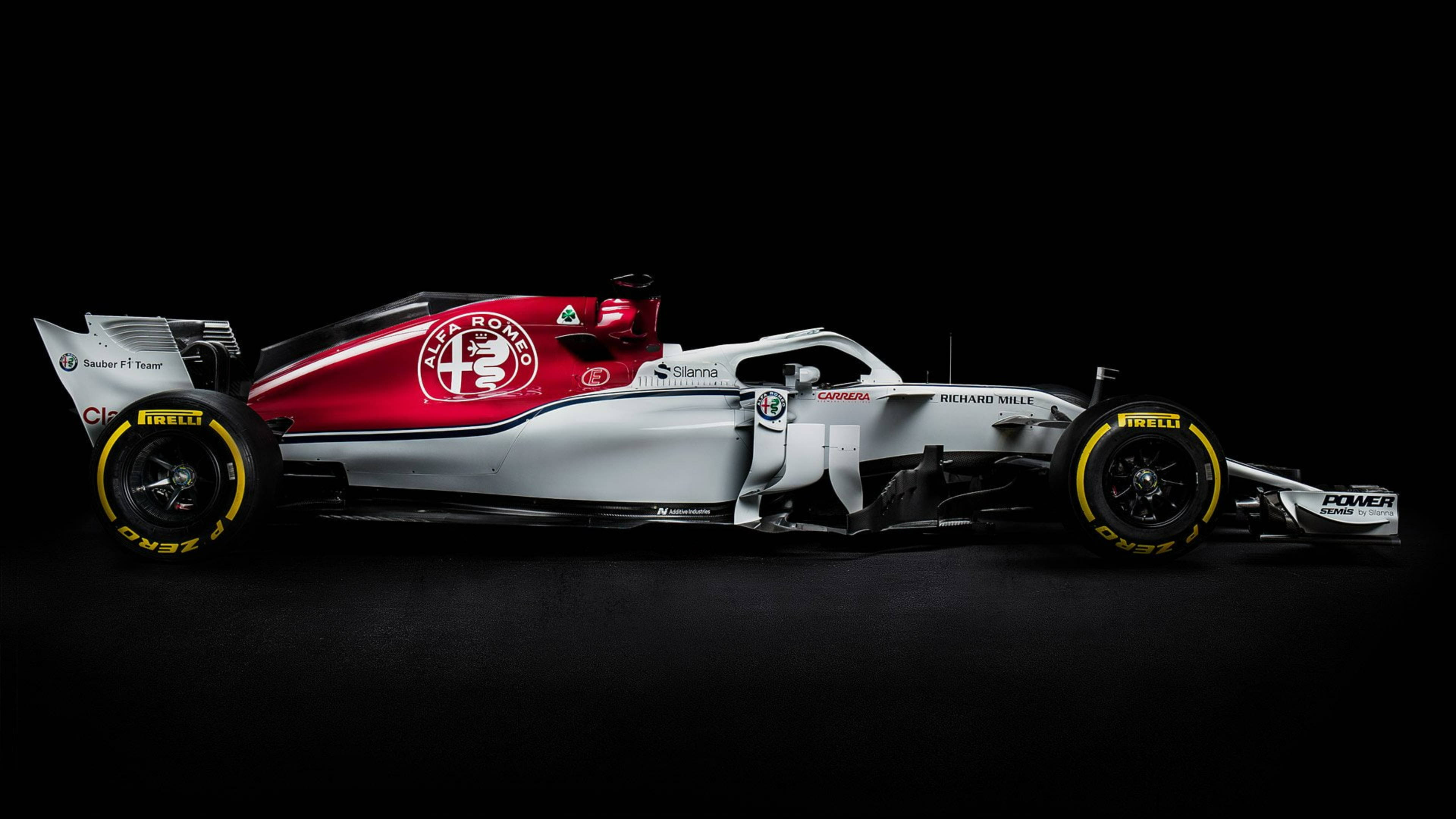 Alfa Romeo 桌布 壁紙 — 一輛紅銀色愛快羅密歐一級方程式賽車，配備黃色倍耐力輪胎，在純黑背景下蓄勢待發。