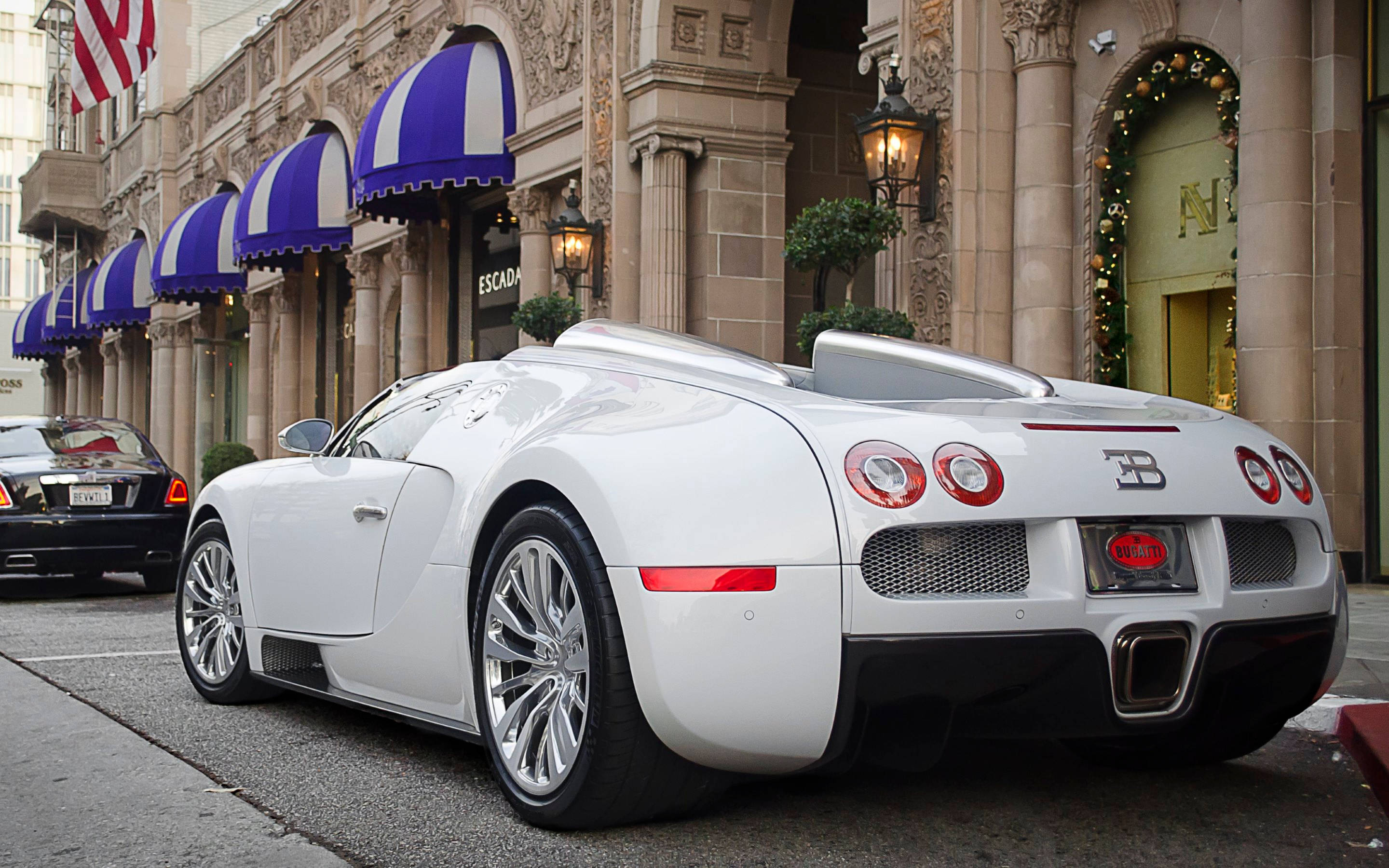 Cool Bugatti 桌布 壁紙 — 一輛純白色的Bugatti Veyron跑車停放在城市街道上，上方有藍白條紋的遮陽篷。