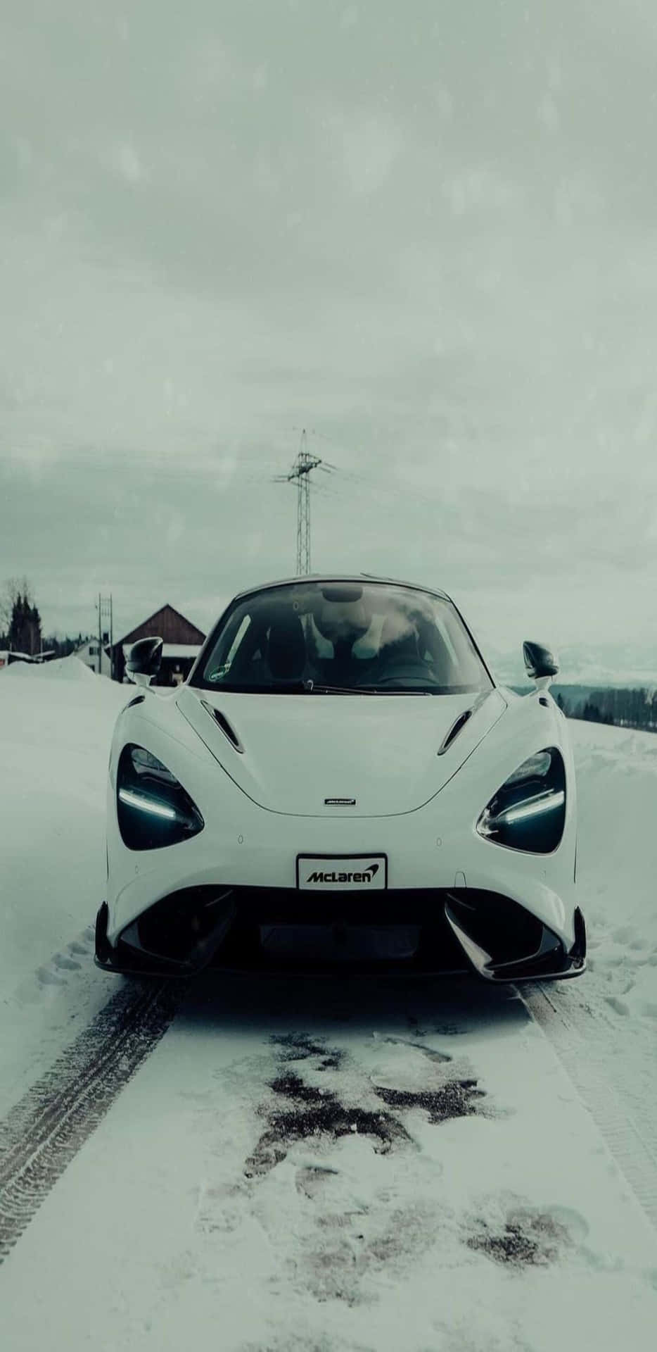  壁紙 — 一輛純白色的McLaren跑車停放在積雪的道路上，天空是陰沉的冬日。