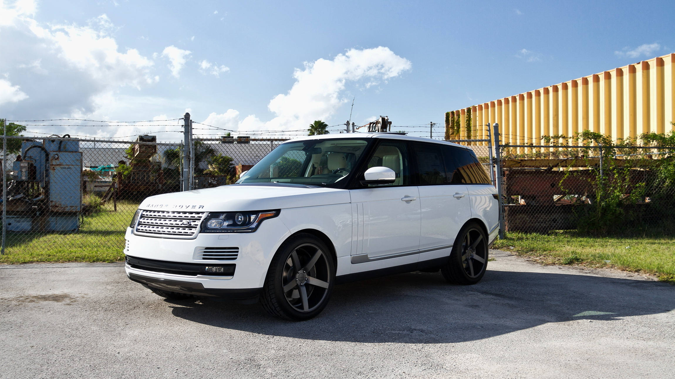 吉普 桌布 壁紙 — 一輛純白色的Range Rover SUV停在瀝青路面上，天空湛藍，白雲點綴。