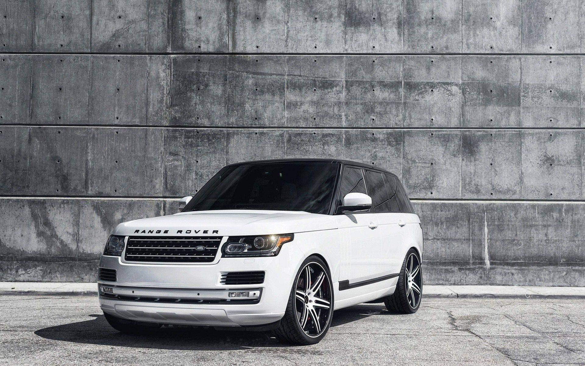 白色Range Rover SUV配備定制輪圈，停靠在混凝土牆前。 — 4K 壁紙