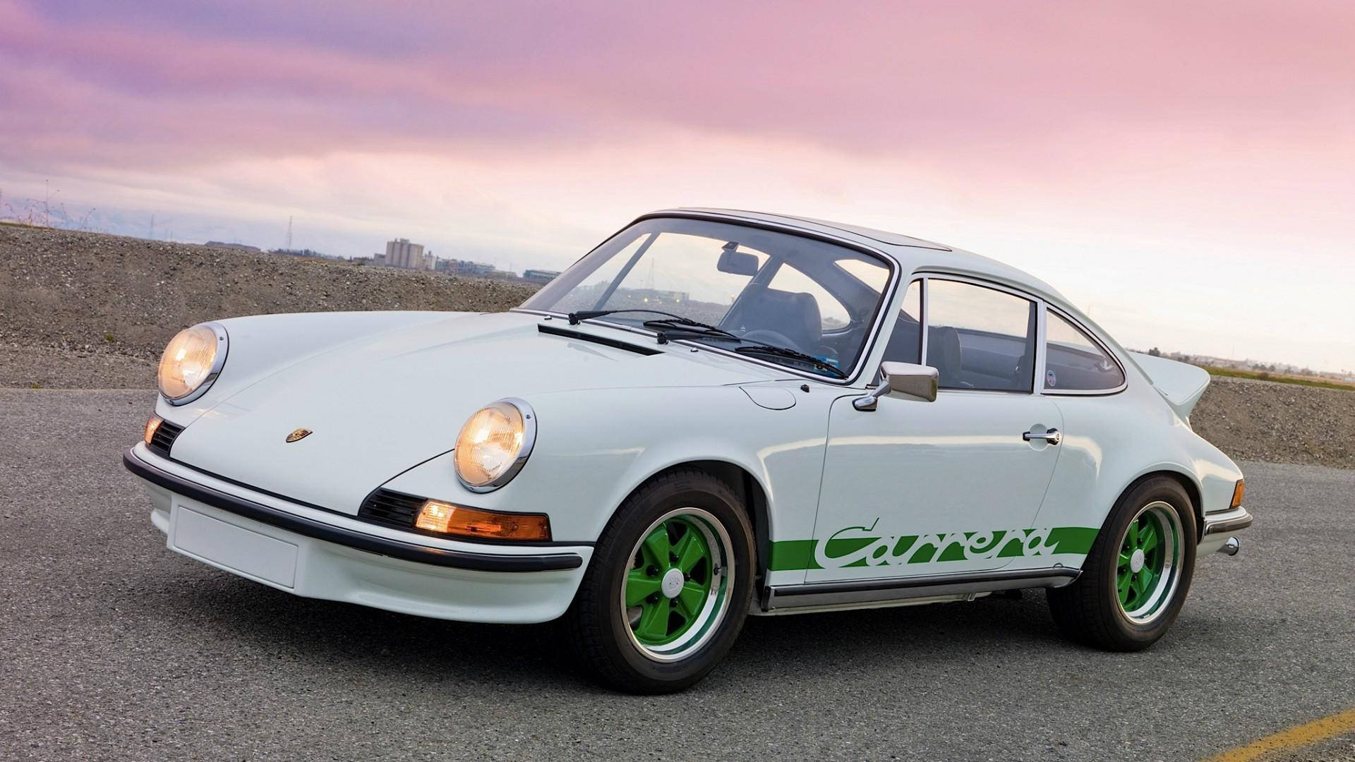 保時捷 911 桌布 壁紙 — 一輛純白色的保時捷911 Carrera，配以鮮綠色車輪，停在瀝青路上，背景是柔和的粉紅與紫色暮色天空。