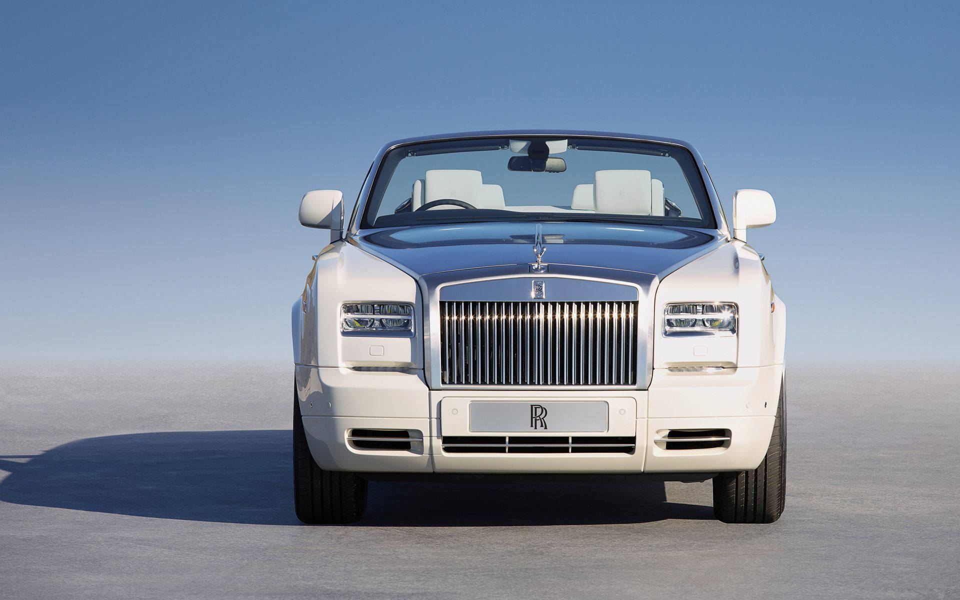 Royce 桌布 壁紙 — 一輛純白色的勞斯萊斯Phantom Drophead Coupe在晴朗藍天下，矗立於廣闊的沙漠平原上。