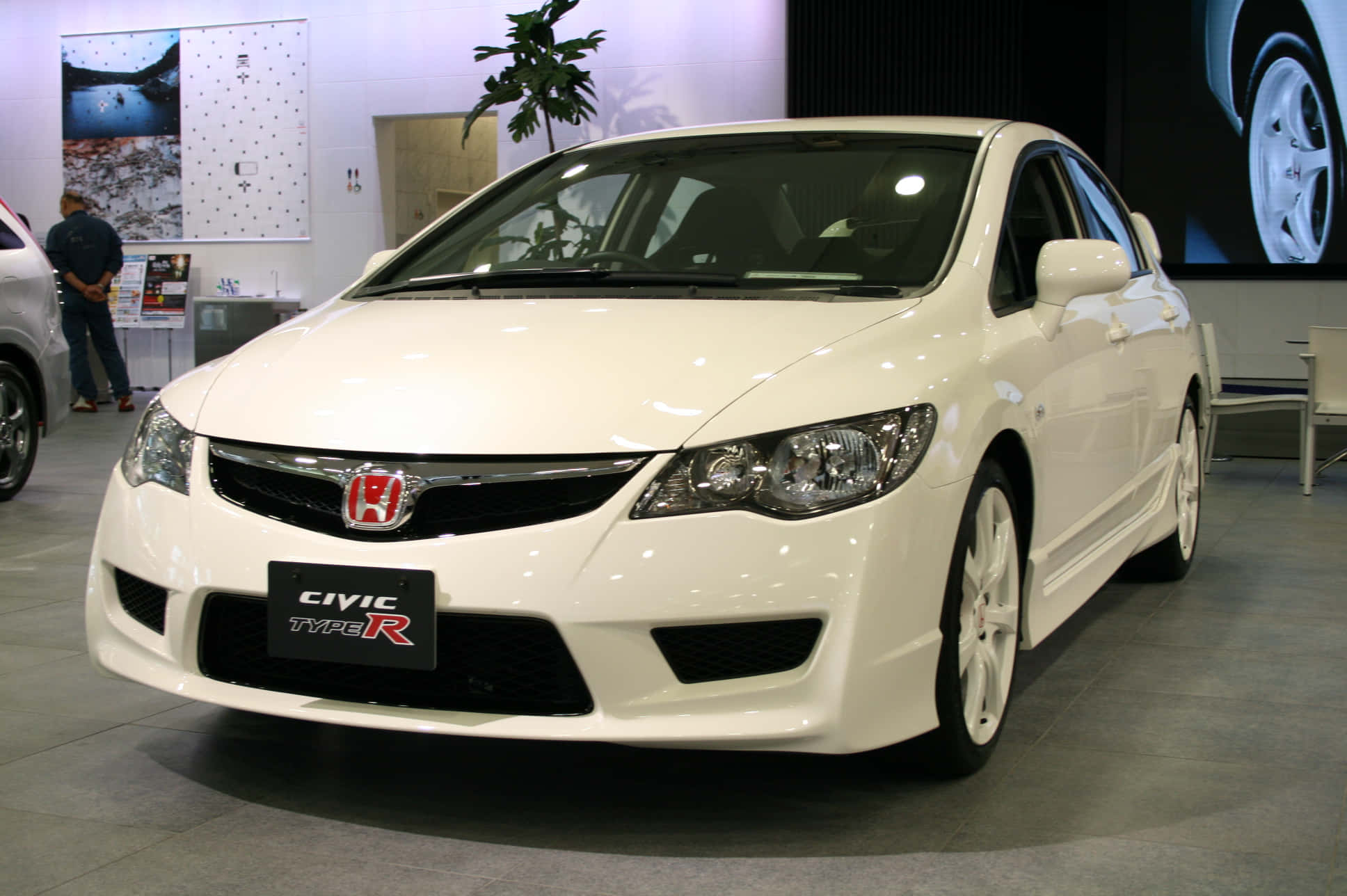 Honda Civic 桌布 壁紙 — 一輛純白色的本田思域Type R房車在明亮的展廳燈光下閃耀，展現出流線型的運動設計。