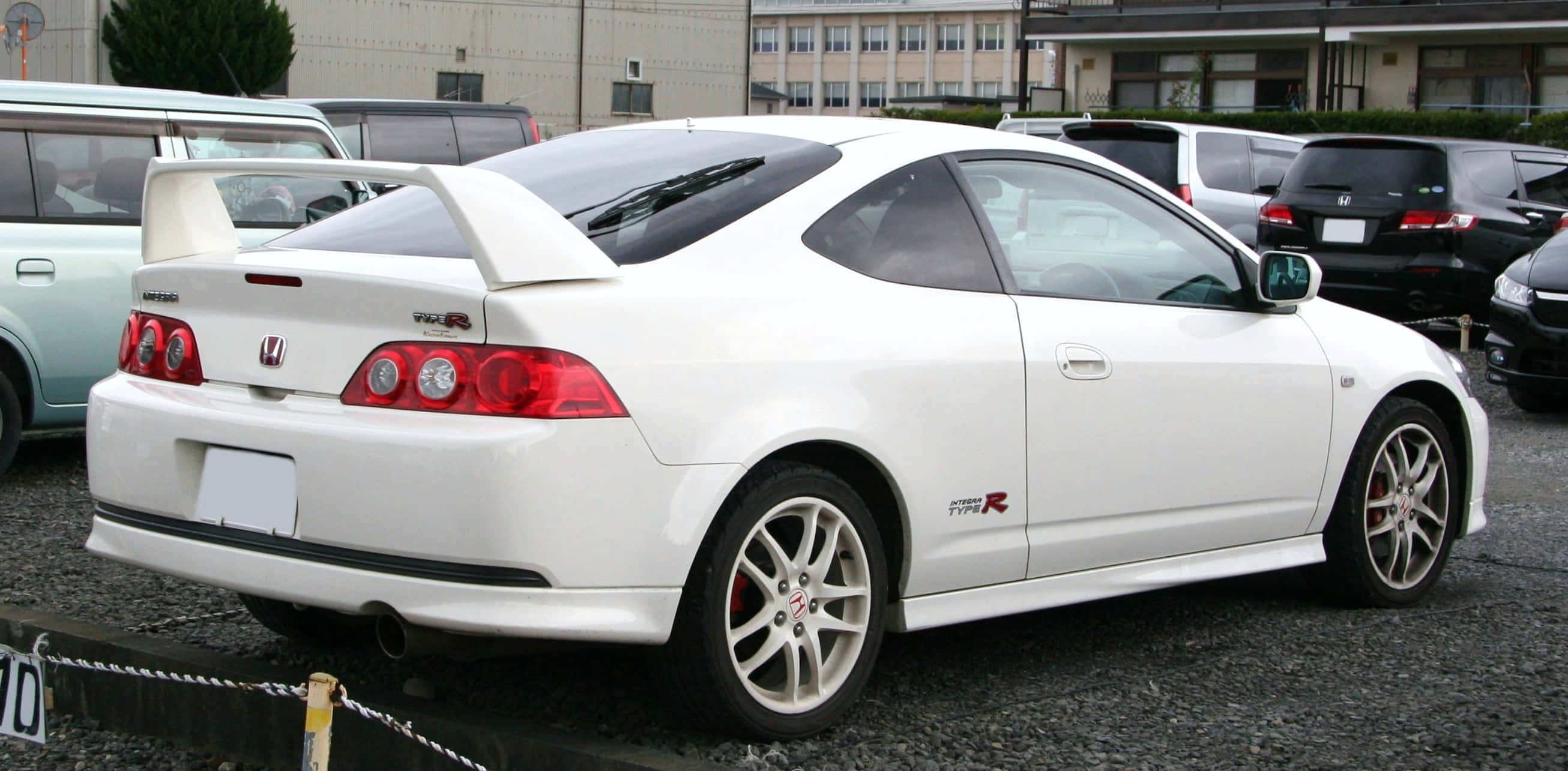 Honda Integra 桌布 壁紙 — 一輛純白色的本田思域Type R雙門跑車停放在碎石停車場，附近有其他車輛。
