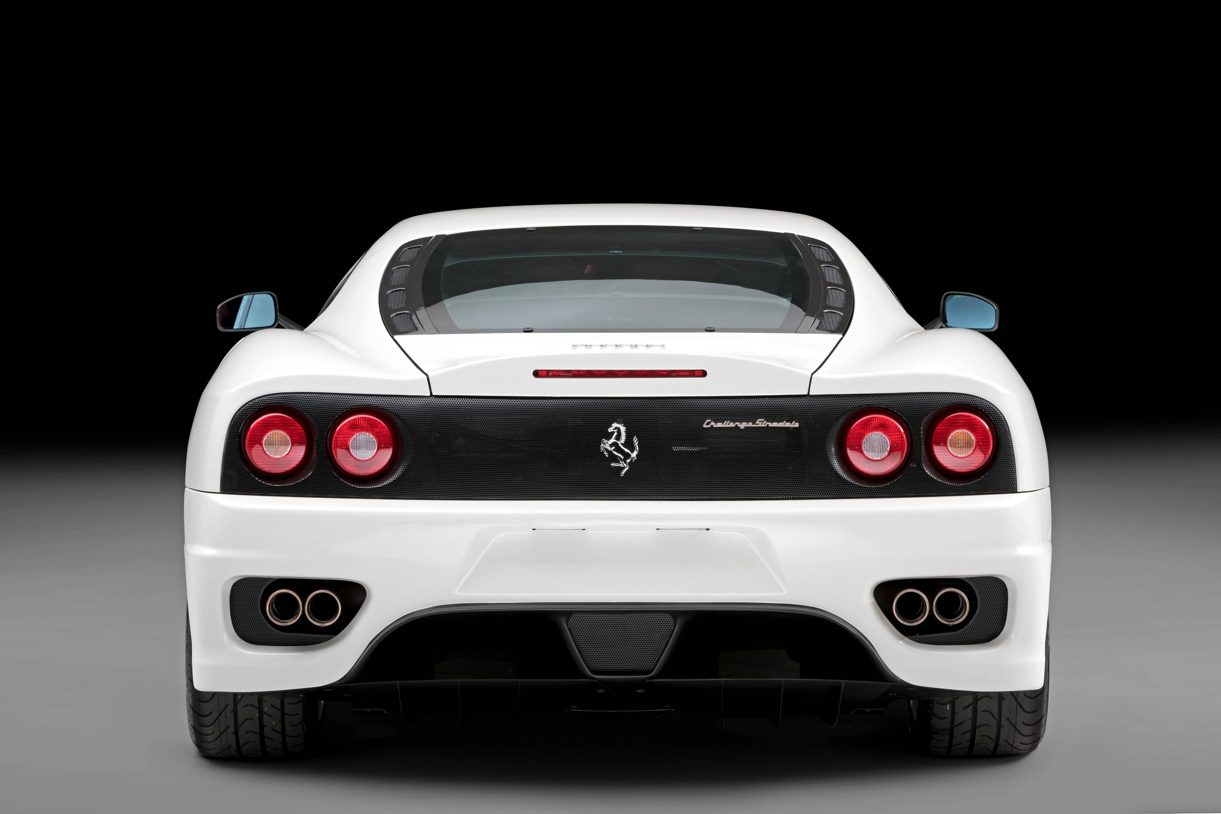 white ferrari 桌布 壁紙 — 一輛純白色的法拉利 Challenge Stradale 跑車，在純黑背景襯托下從後方觀看。