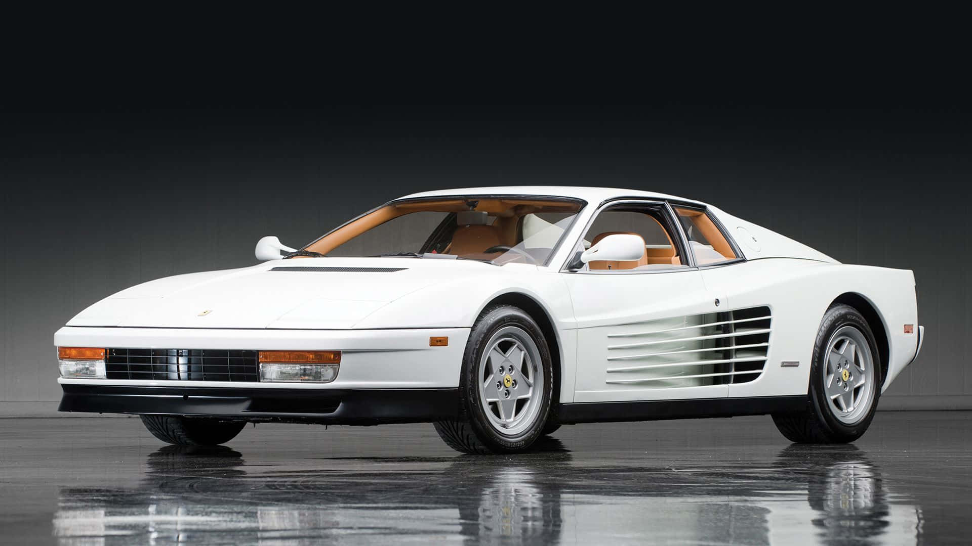 Ferrari Testarossa 桌布 壁紙 — 一輛純白色的法拉利 Testarossa 在攝影棚燈光下閃耀，配備棕褐色皮革內飾和標誌性的側面通風口。