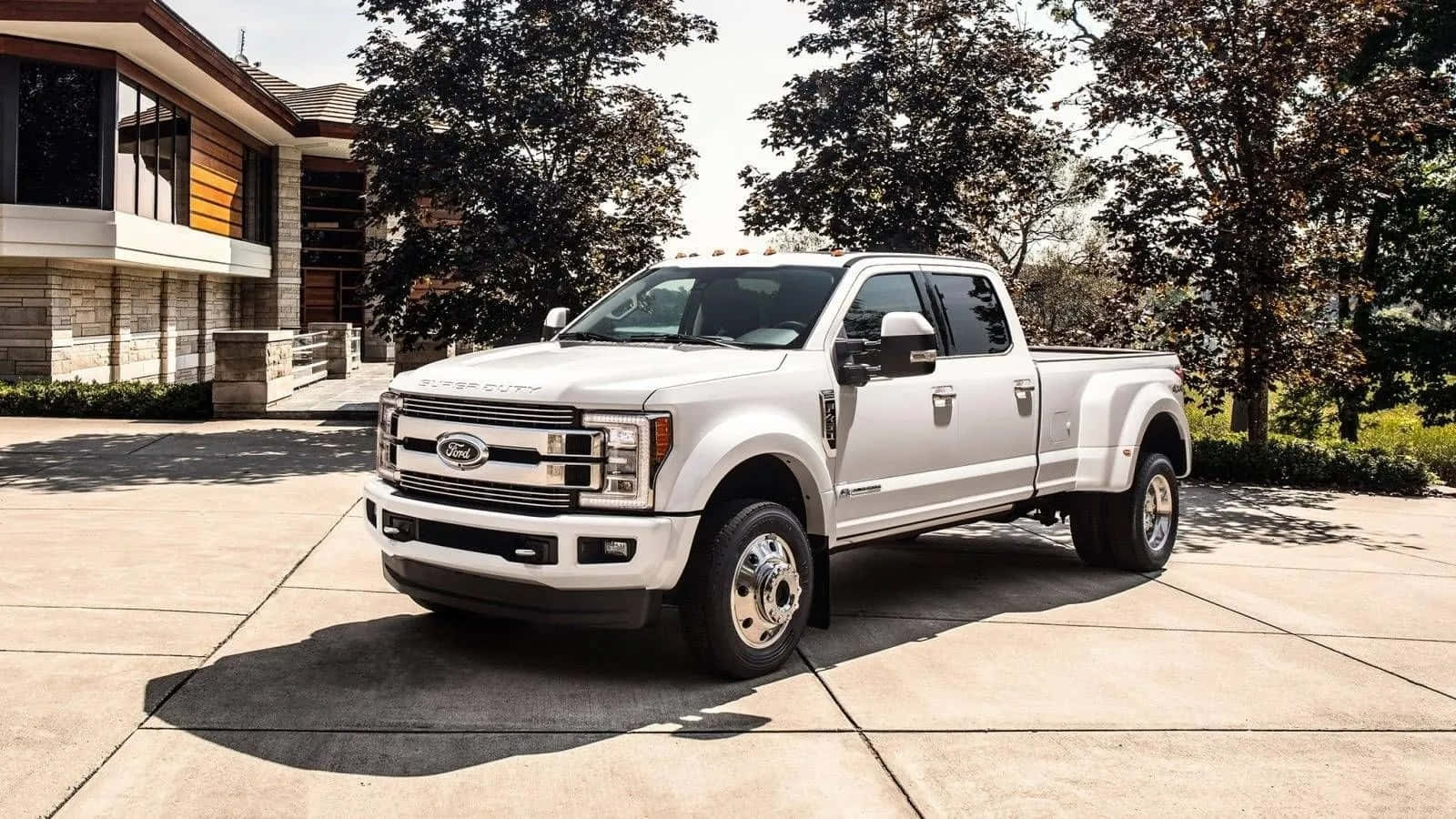 福特 桌布 壁紙 — 一輛純白色的福特F-350 Super Duty卡車停放在現代化房屋前的混凝土車道上，樹木投下陰影。