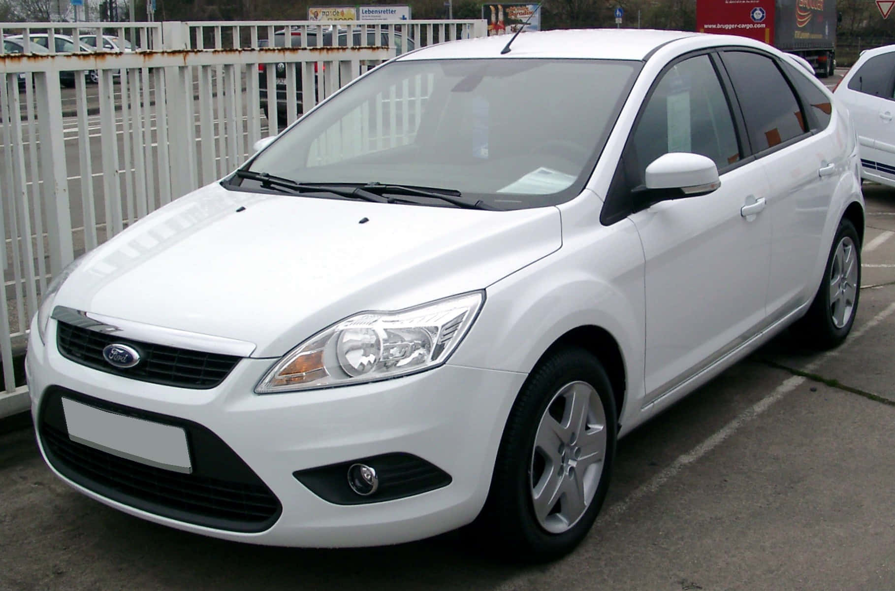 Ford Focus 桌布 壁紙 — 一輛純白色的福特福克斯掀背車停在白天白色圍欄旁的停車場。
