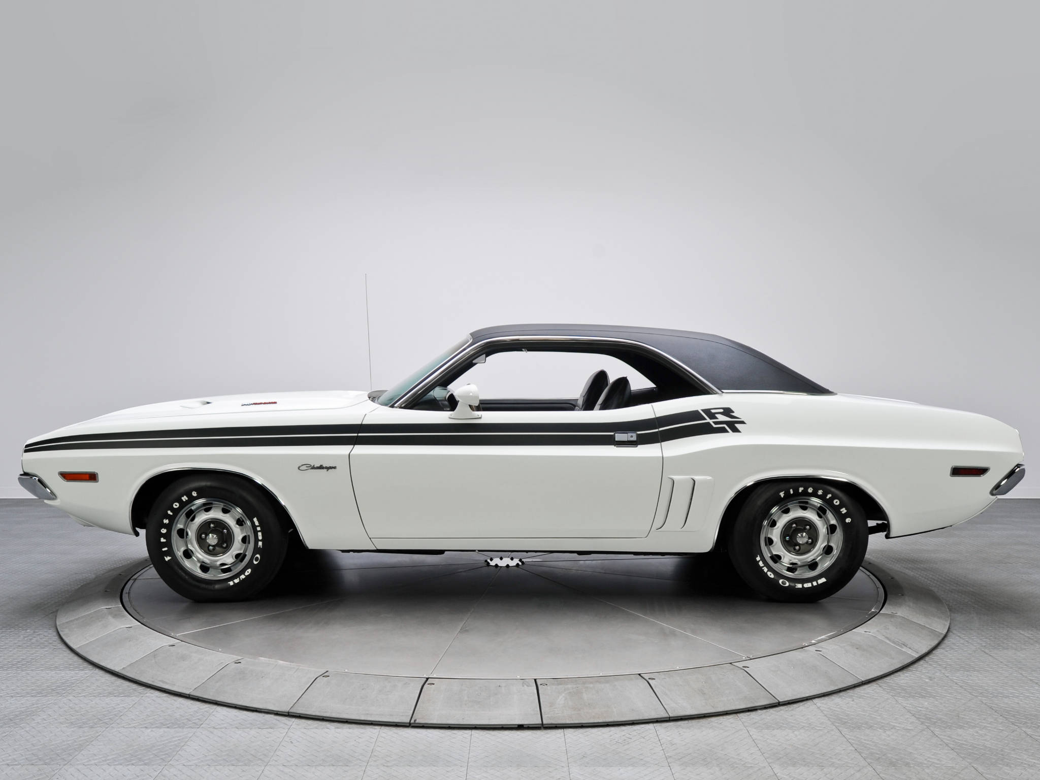 Challenger 桌布 壁紙 — 一輛純白色的經典肌肉車，帶有黑色賽車條紋，居中放置在圓形轉盤上，背景為中性灰色攝影棚。