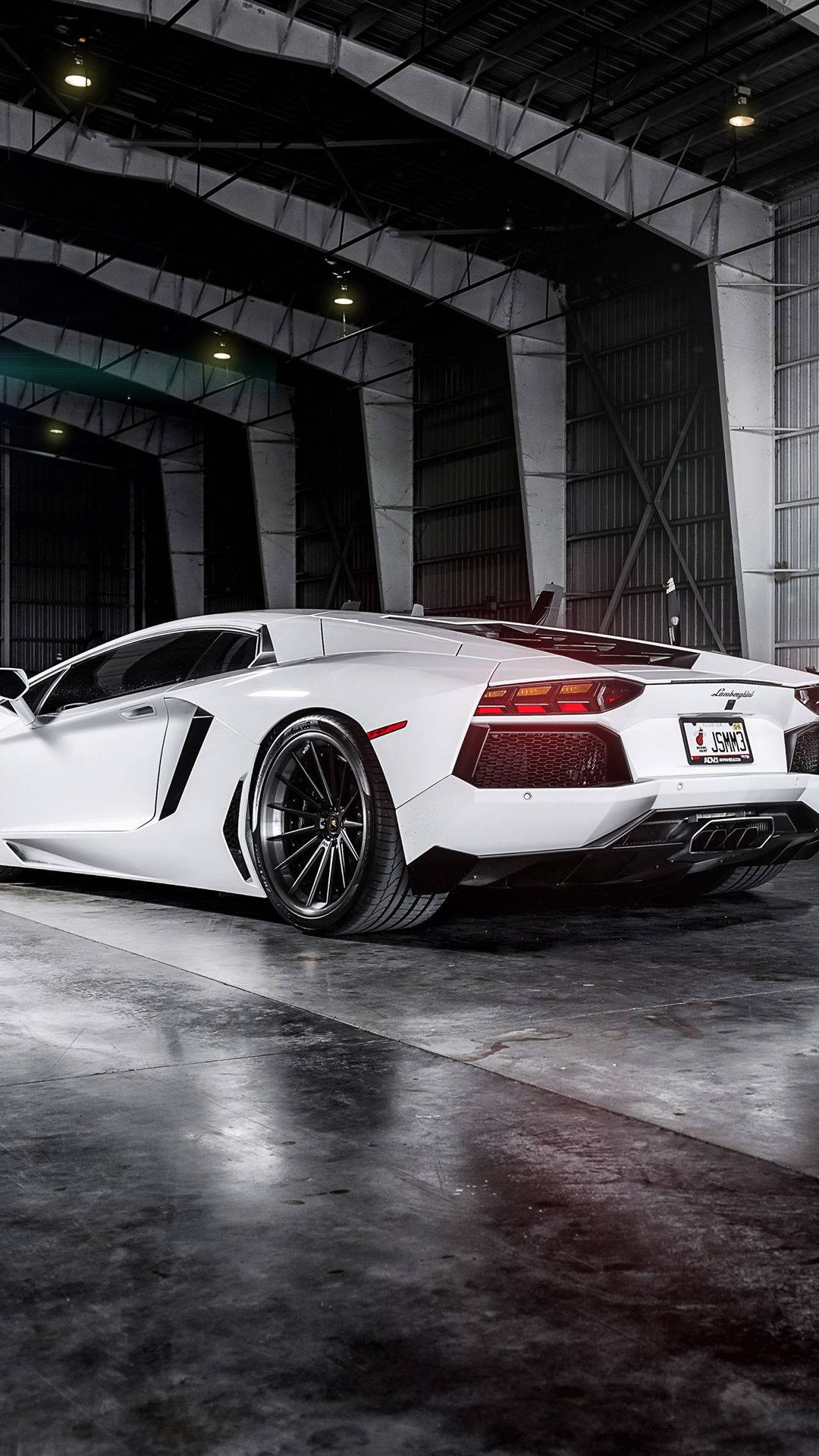 汽車 桌布 壁紙 — 一輛純白色的藍寶堅尼Aventador停放在光線昏暗的工業車庫中，帶有裸露的鋼樑和混凝土地板。