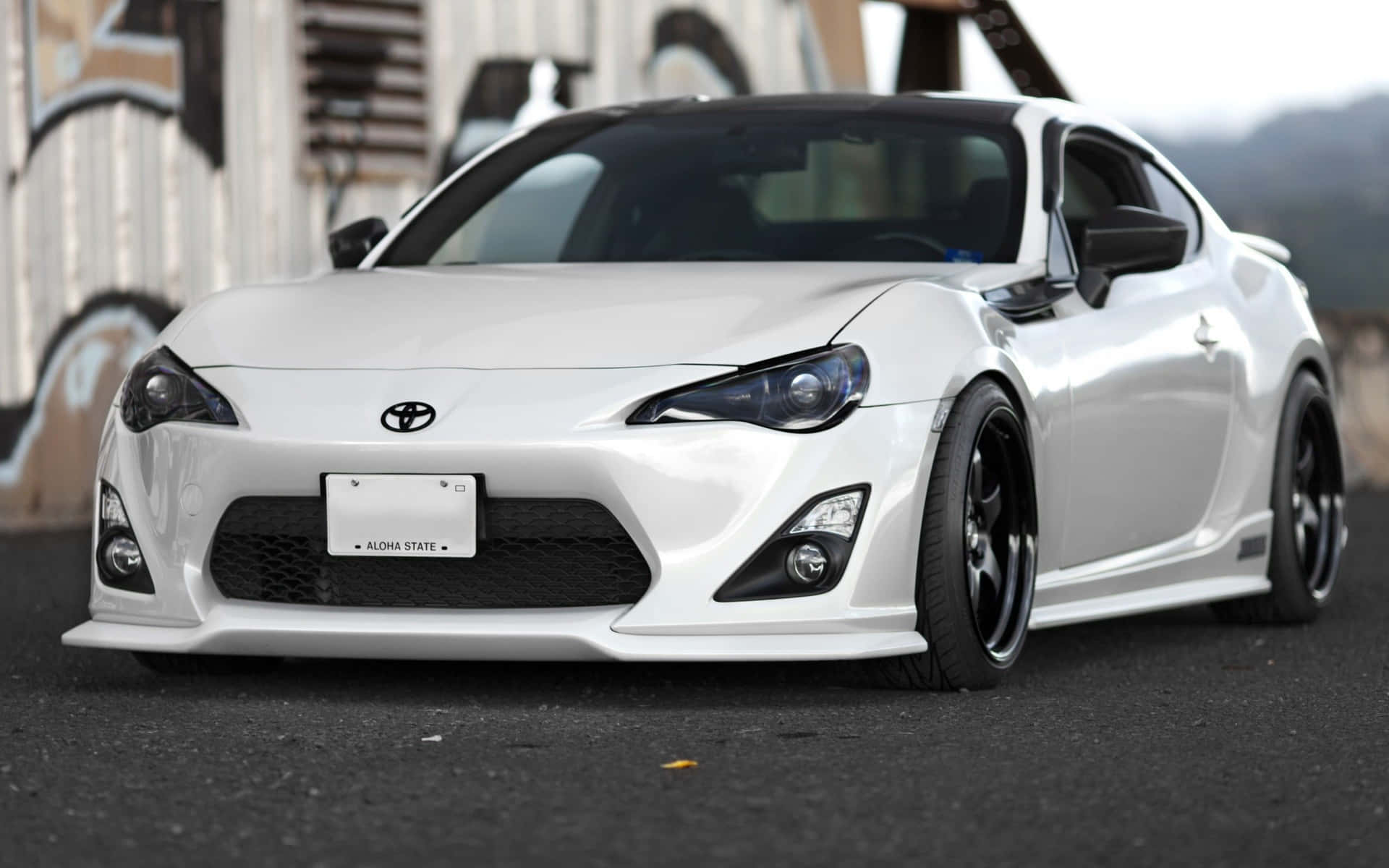 白色豐田86跑車配黑色輪圈，停在塗鴉牆附近。 — Toyota Supra Mk4 壁紙