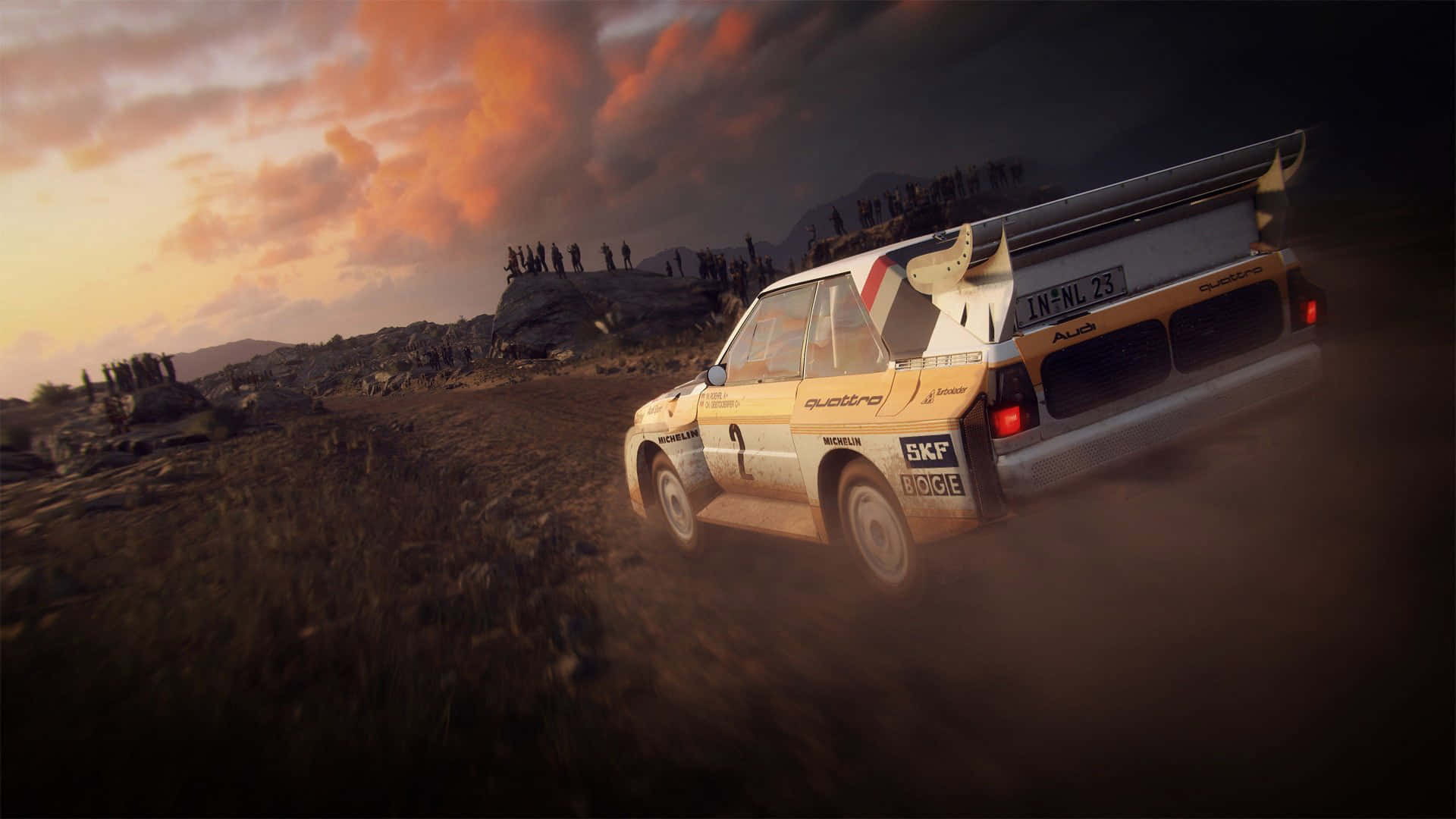 1920x1080 Dirt Rally 桌布 壁紙 — 一輛經典拉力賽車在熾熱的夕陽天空下，穿越崎嶇地形時揚起灰塵。