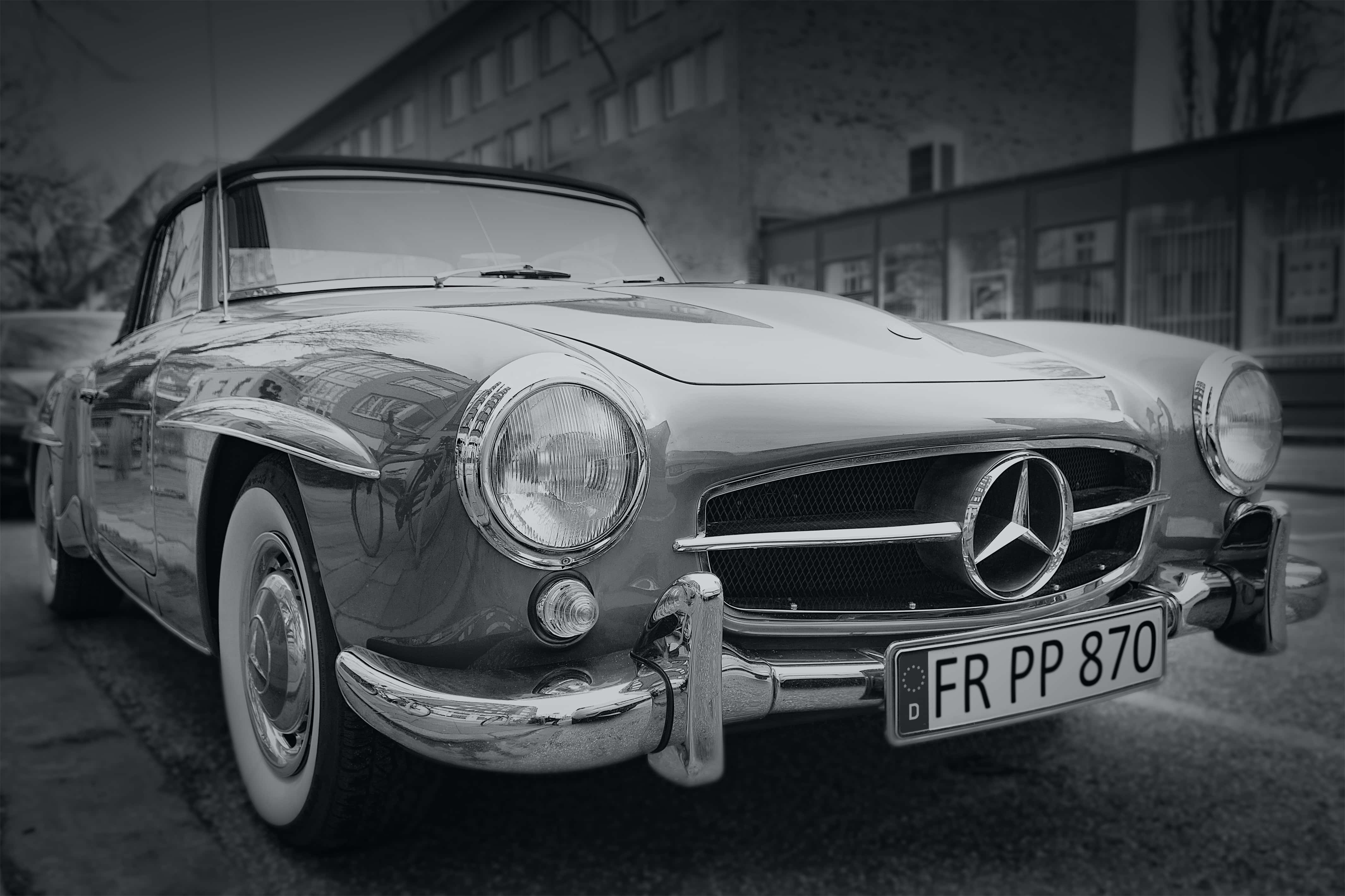 Classic Mercedes 桌布 壁紙 — 一輛經典的梅賽德斯-奔馳300SL鷗翼車停在街上，帶有復古鍍鉻飾面和柔和的單色調。