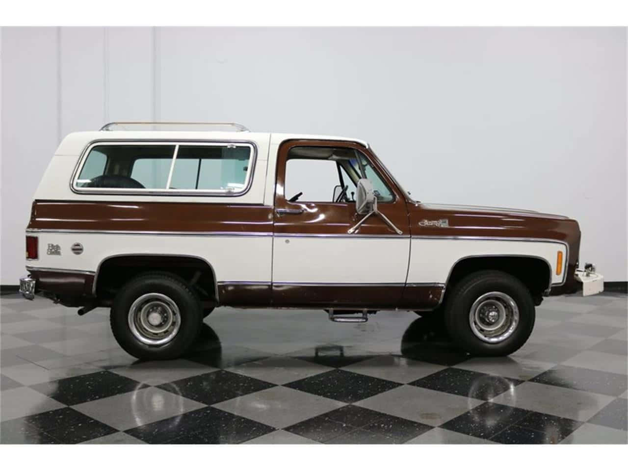 Gmc Jimmy 桌布 壁紙 — 一輛經典的雙色調棕色和白色雪佛蘭K5 Blazer SUV自豪地停在明亮的室內展廳的光澤黑白棋盤格地板上。