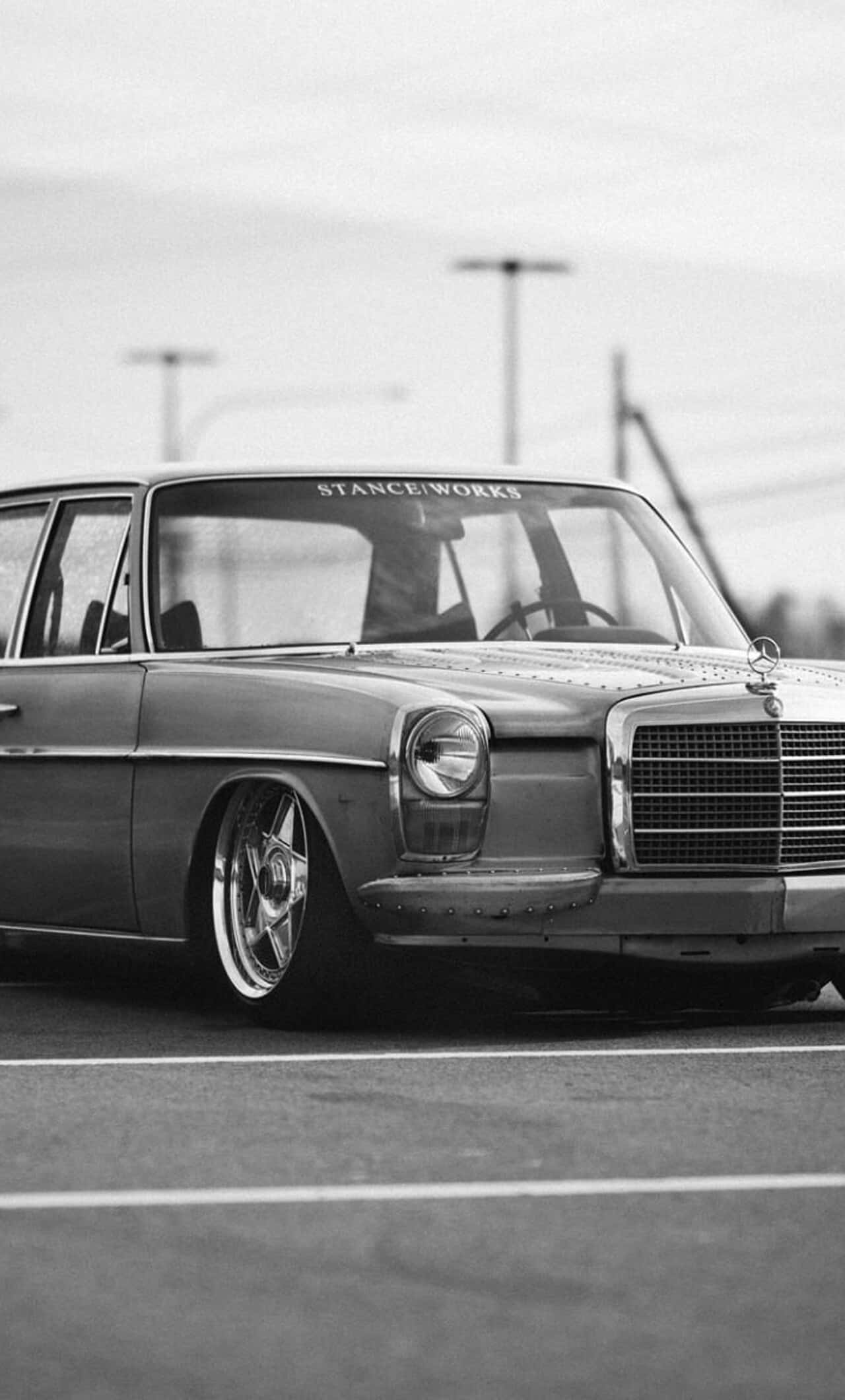 Classic Mercedes 桌布 壁紙 — 一輛經典賓士汽車降低車身並裝上訂製輪圈，停在瀝青停車場的黑白照片。