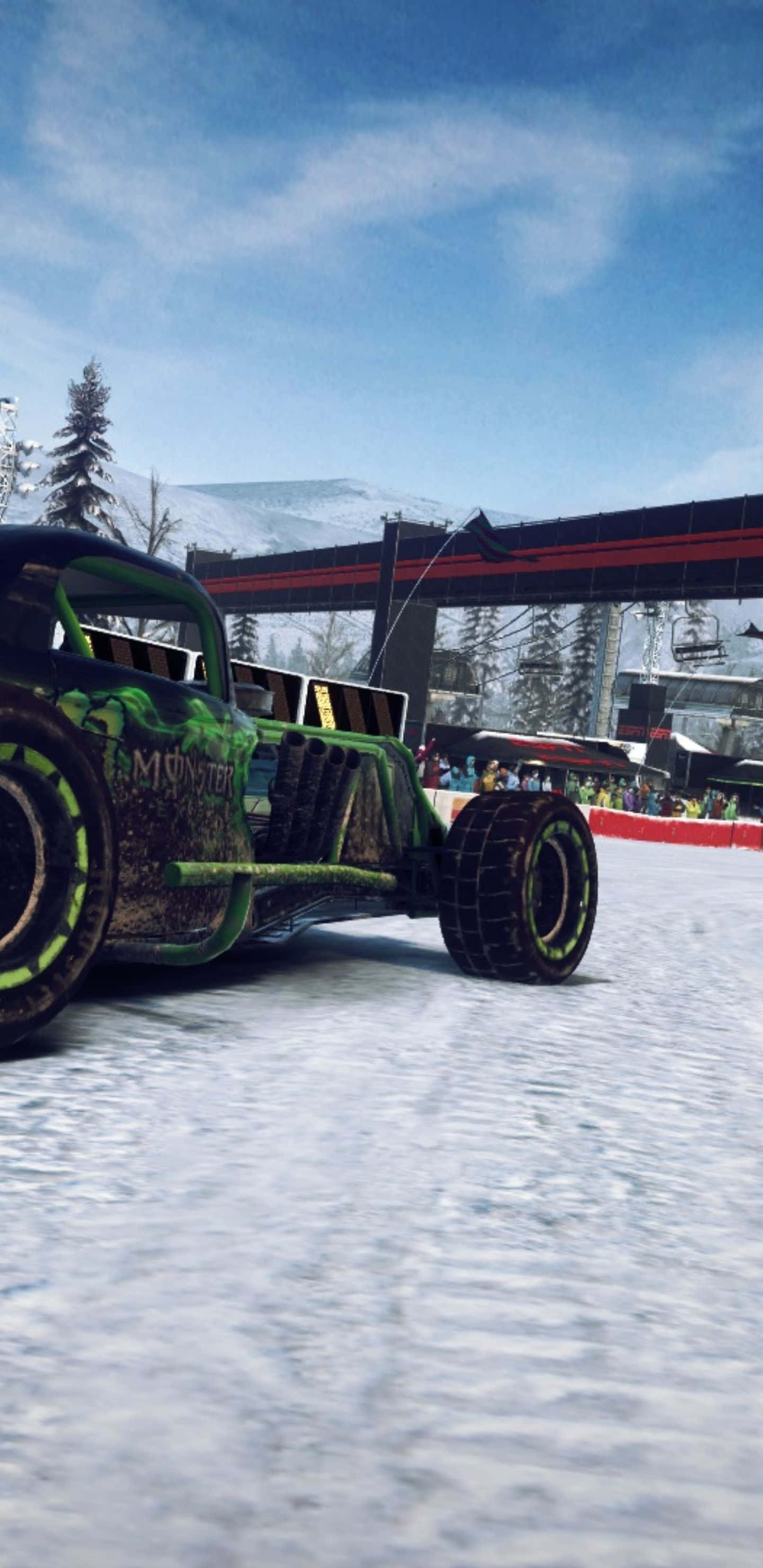 Monster Truck 桌布 壁紙 — 一輛綠色怪獸卡車帶著發光輪胎在滑雪勝地附近的雪地上奔馳，天空清澈湛藍。