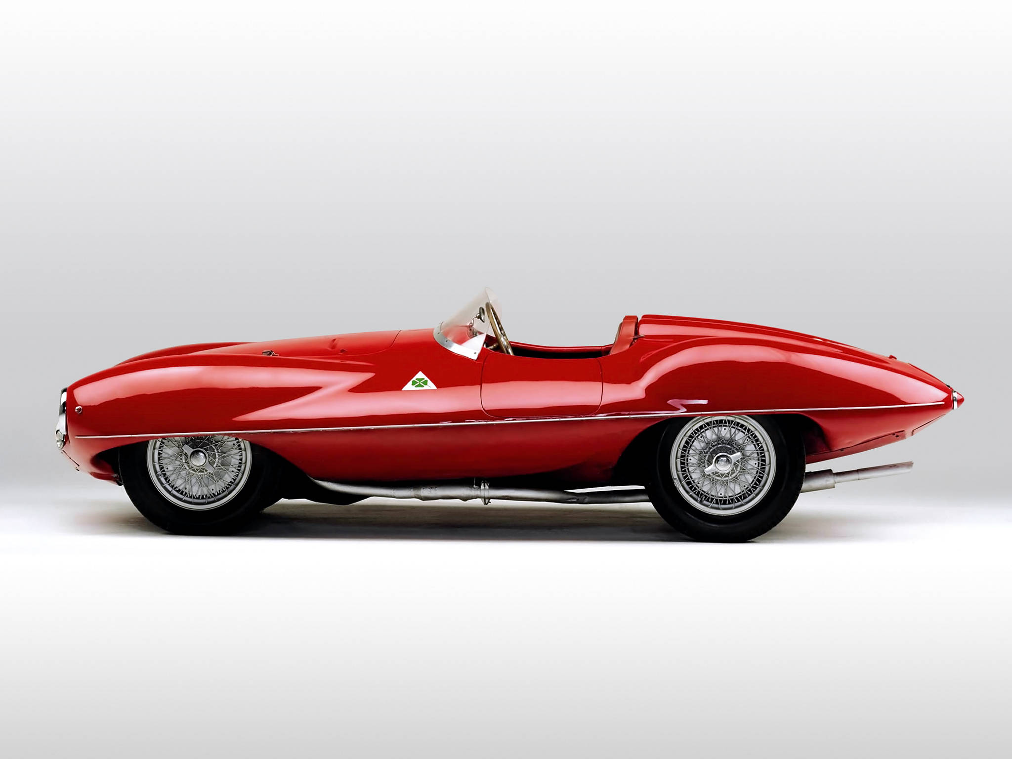 alfa romeo iPhone 桌布 壁紙 — 一輛線條流暢的紅色復古跑車，配備鍍鉻輪圈和光澤飾面，在純白色背景上以側面輪廓展示。