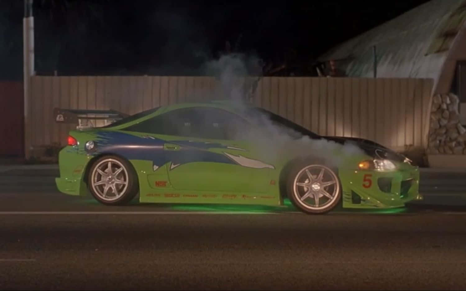 Fast And Furious 桌布 壁紙 — 一輛萊姆綠和藍色的跑車在夜間甩尾，輪胎在街道上冒出煙霧。