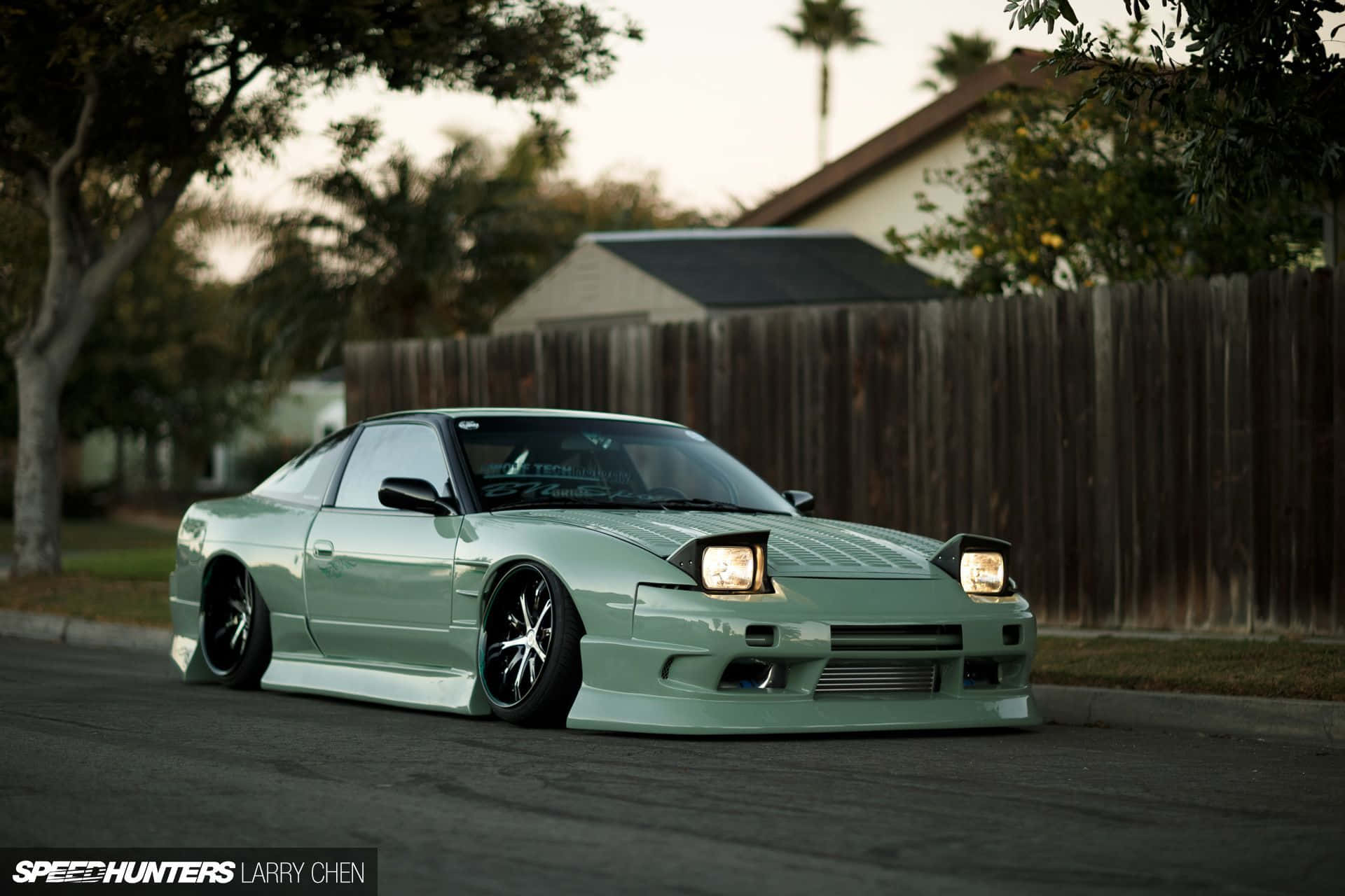 Nissan Silvia S13 桌布 壁紙 — 一輛薄荷綠改裝日產S14轎跑車，車頭燈發亮，停泊在黃昏的郊區街道上。