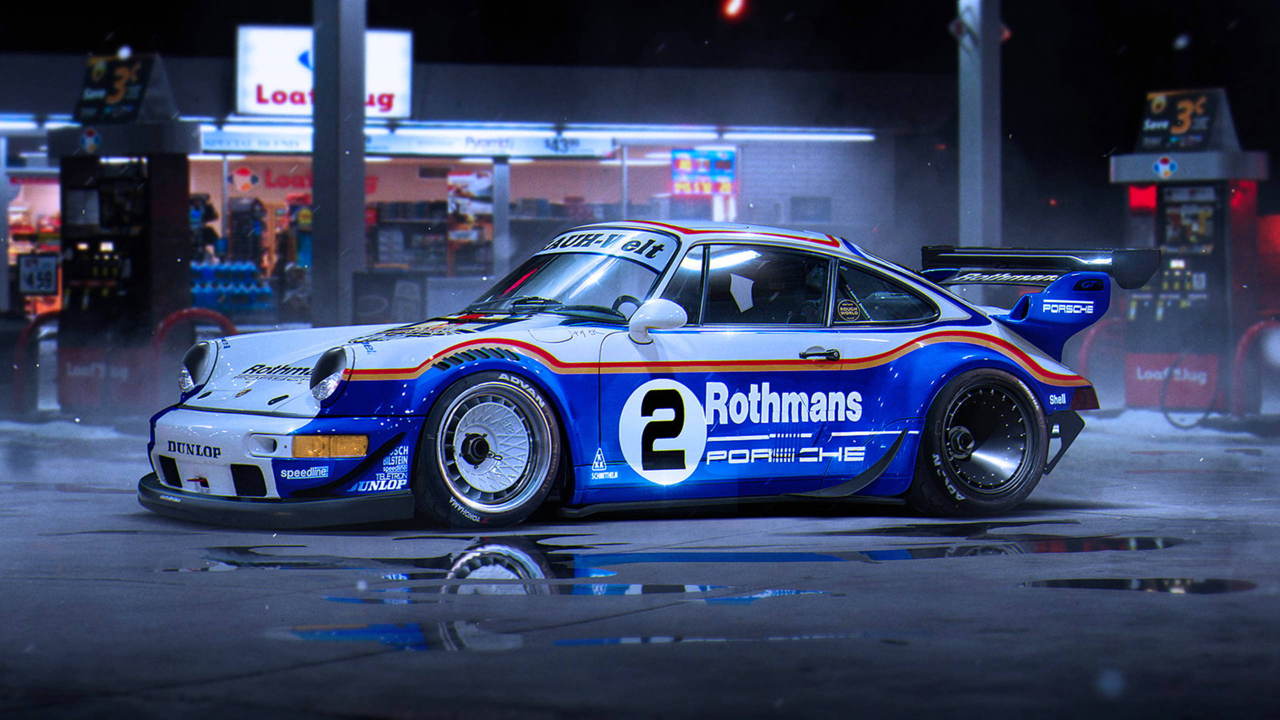 賽車 桌布 壁紙 — 一輛藍白色的 Rothmans Porsche 911 賽車在夜間濕漉漉的加油站霓虹燈下閃閃發光。