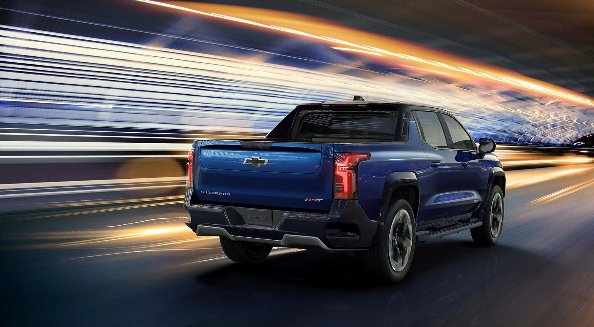Chevrolet 桌布 壁紙 — 一輛藍色 Chevrolet Silverado F-150 RST 皮卡在夜間高速行駛於高速公路，燈光拖曳形成動態模糊效果。