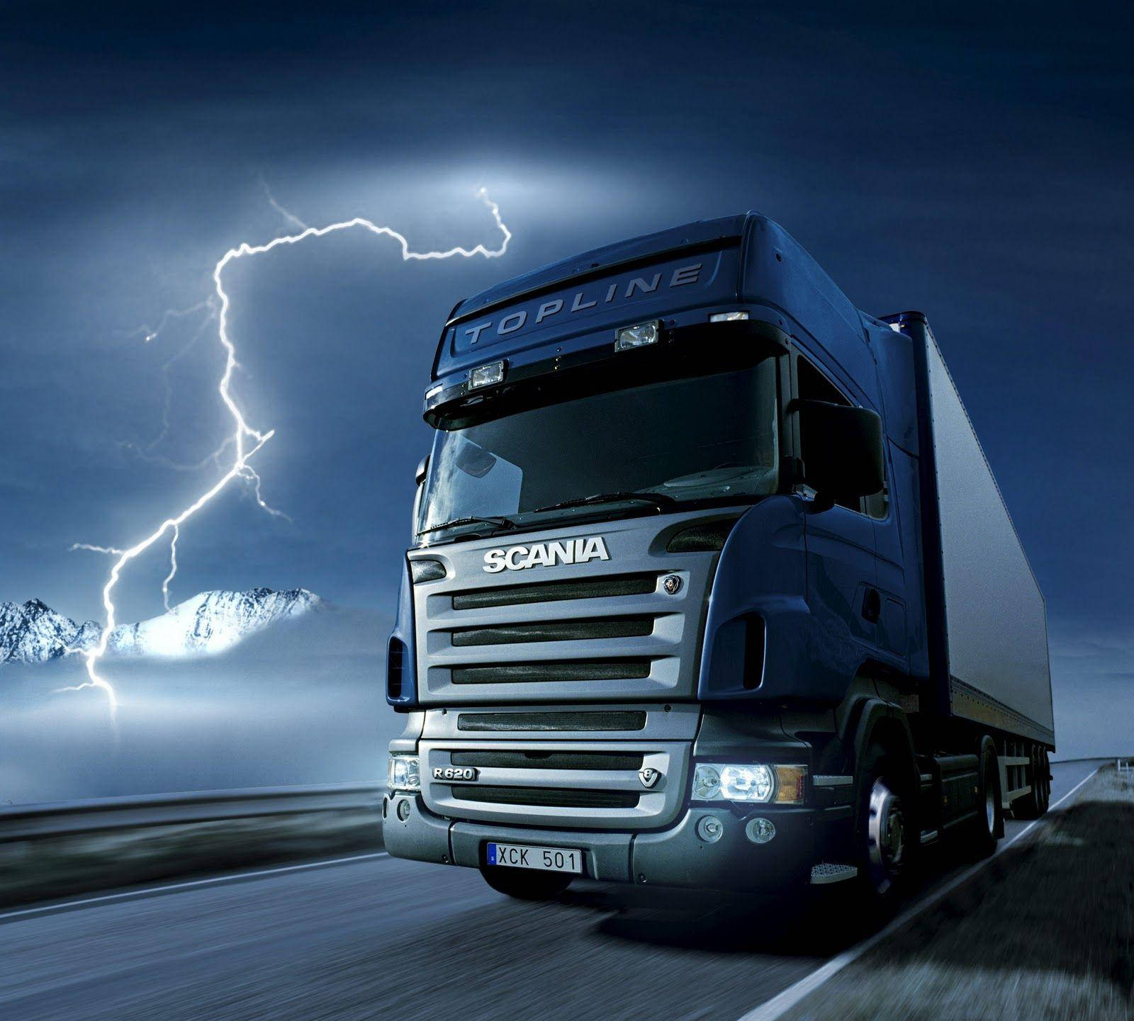 Trucks 桌布 壁紙 — 一輛藍色 Scania Topline R620 卡車在戲劇性的雷暴下高速行駛在高速公路上，背景是白雪覆蓋的山脈。