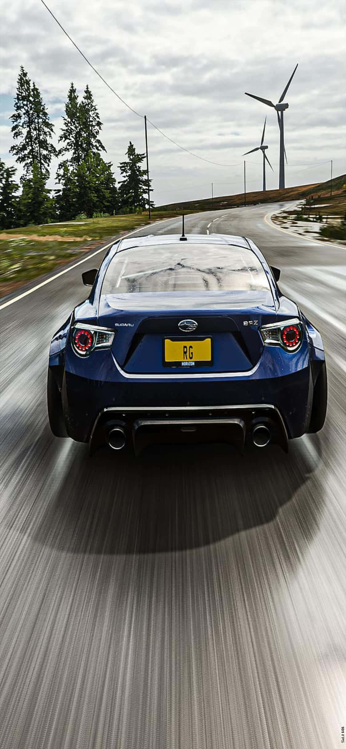 iPhone Xs Forza Horizon 4 桌布 壁紙 — 一輛藍色Subaru BRZ在陰天背景下，沿著蜿蜒的道路疾馳，背景有風力渦輪機和松樹。