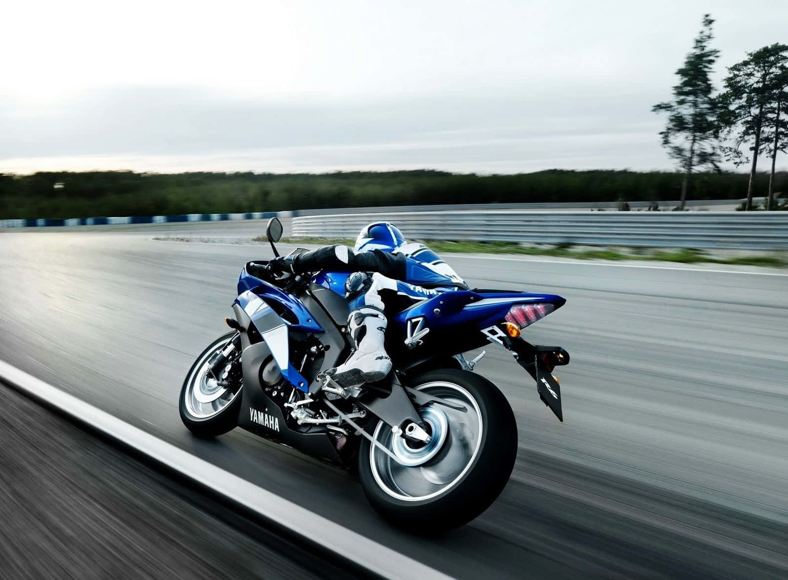 機車 桌布 壁紙 — 一輛藍色Yamaha跑車在賽道上傾斜入彎，動態模糊傳達高速與精準。