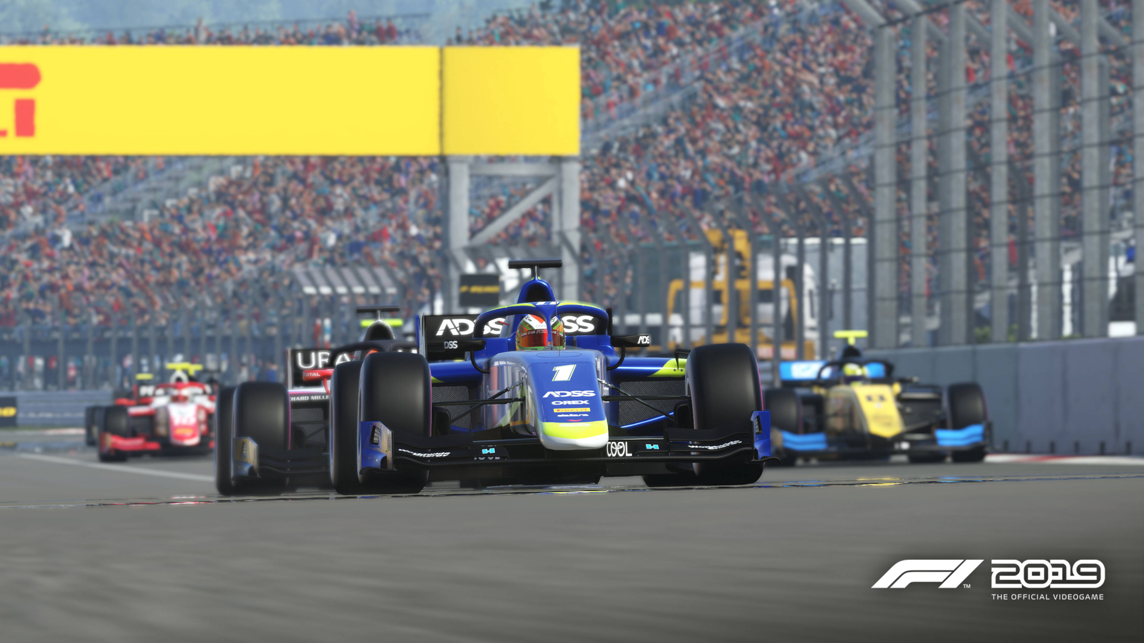 F1 2019 壁紙 桌布 壁紙 — 一輛藍色一級方程式賽車，車身號碼為一，在賽道上奔馳，背景是喧鬧的人群和其他賽車手。