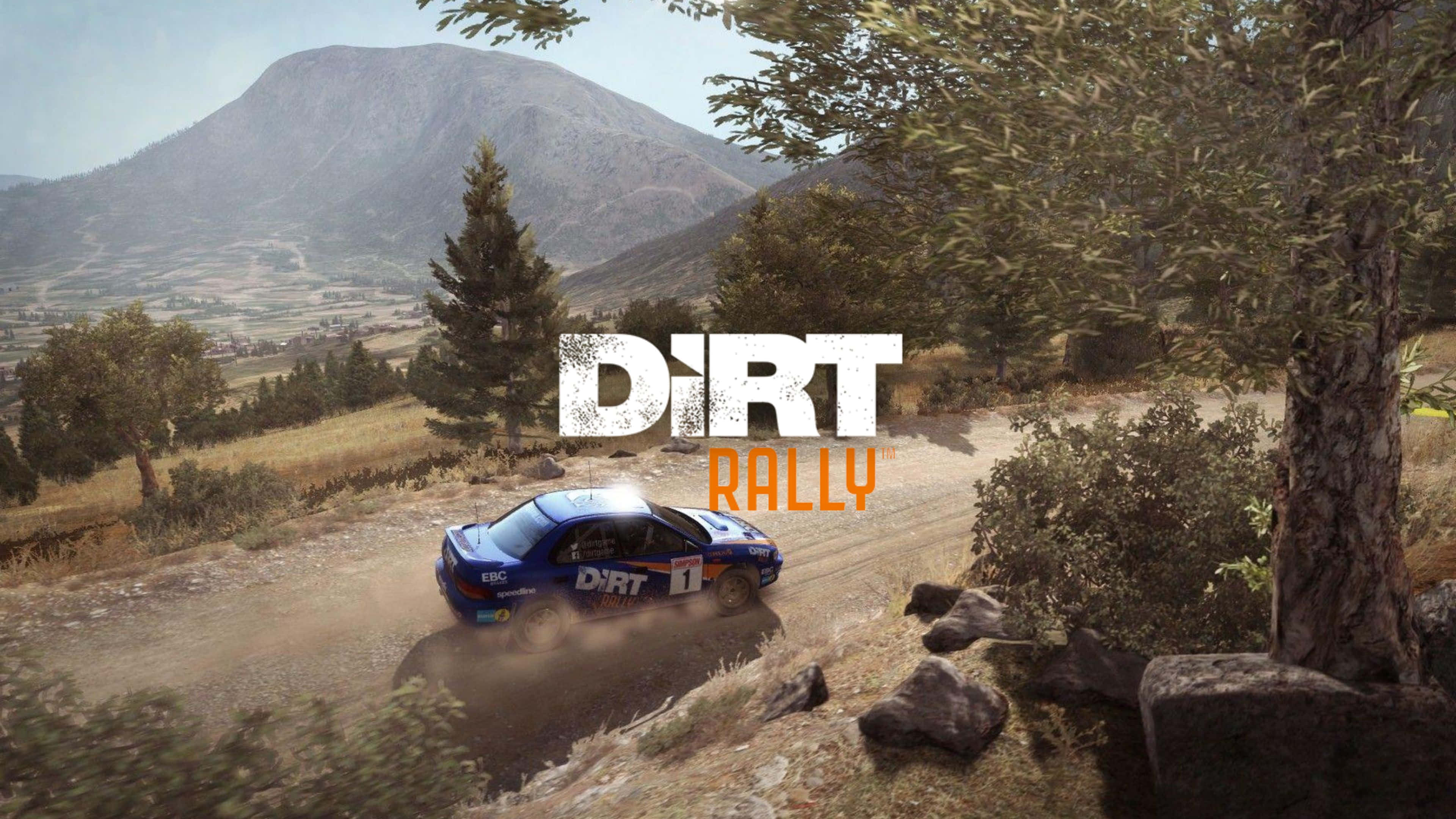 4K Dirt Rally 桌布 壁紙 — 一輛藍色拉力賽車在晴朗天空下，於蜿蜒的山路上揚起塵土，周圍環繞著樹木和遠山。