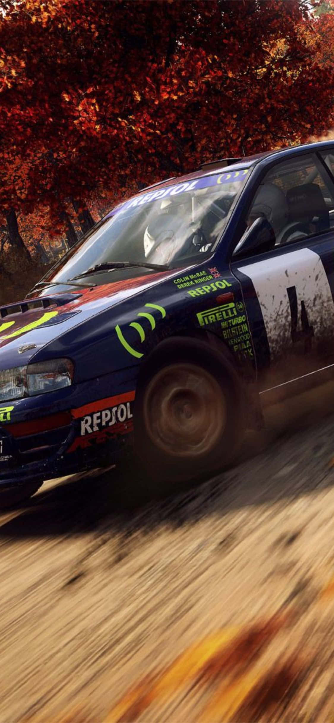 iPhone Xs Dirt Rally 桌布 壁紙 — 一輛藍色拉力賽車在森林中疾馳，火紅的秋葉在其旋轉的車輪周圍飛舞。