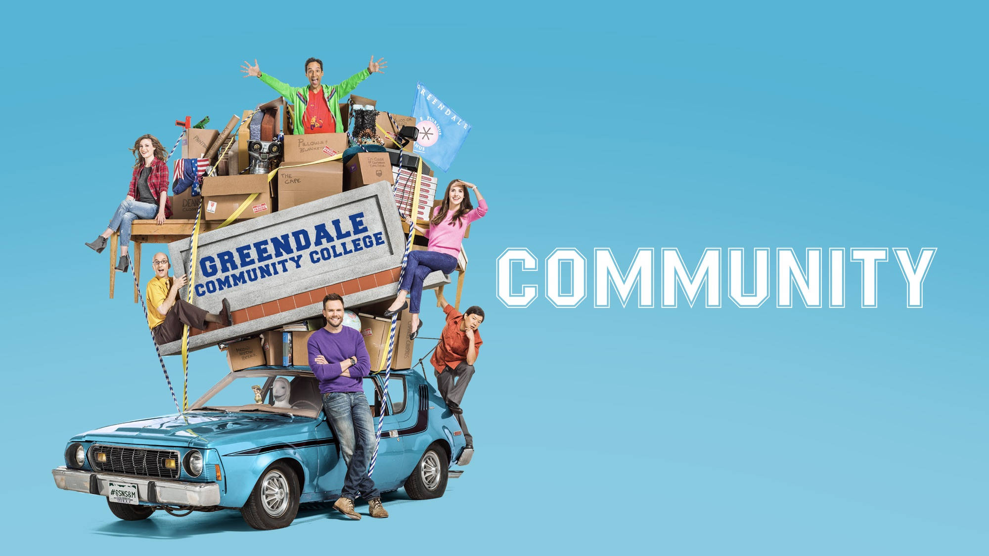 Community 桌布 壁紙 — 一輛藍色汽車，裝滿了電視劇《Community》中的盒子和人物，背景為純藍色。