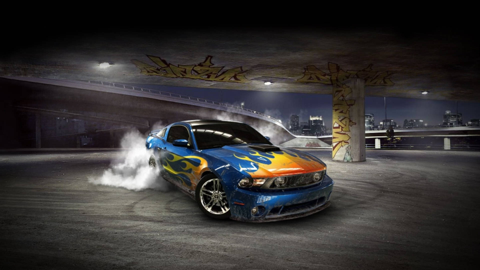 Cool Car 桌布 壁紙 — 一輛藍色火焰塗裝的肌肉車在夜間於塗鴉覆蓋的天橋下飄移，輪胎冒出滾滾濃煙。
