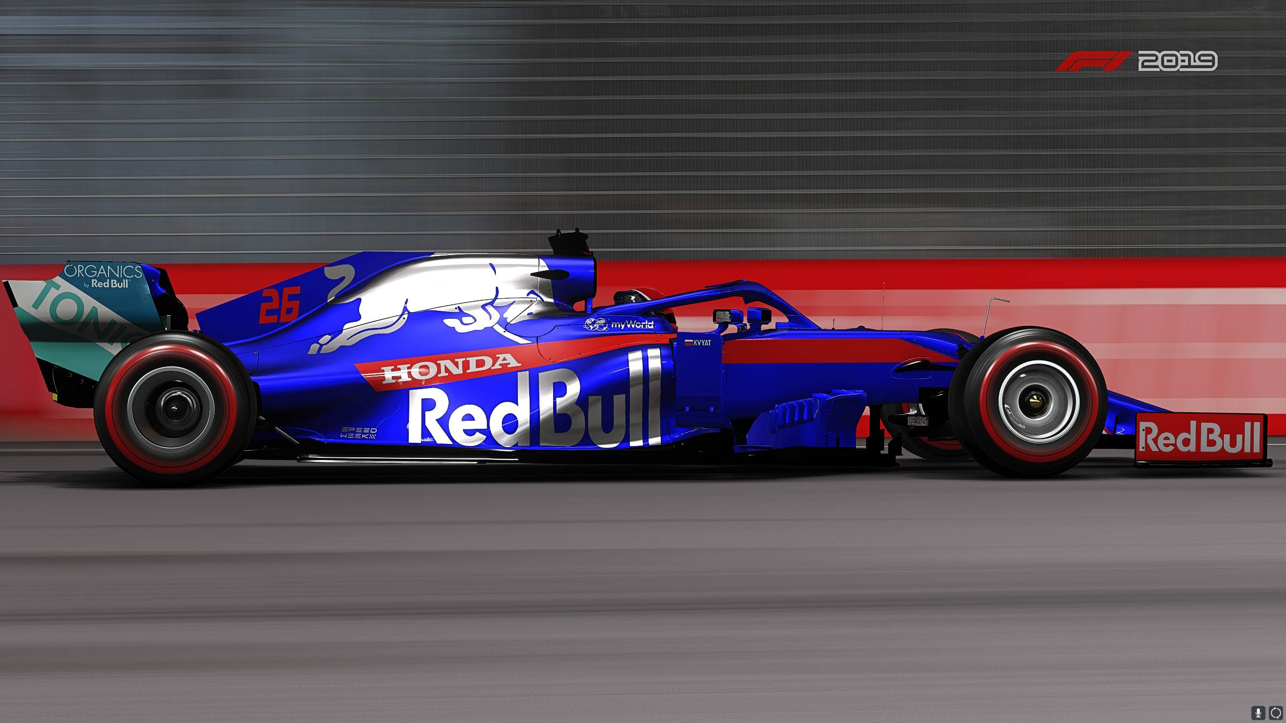 F1 2019 壁紙 桌布 壁紙 — 一輛藍色紅牛車隊一級方程式賽車高速駛過紅色和灰色的賽道護欄，帶有動態模糊效果。